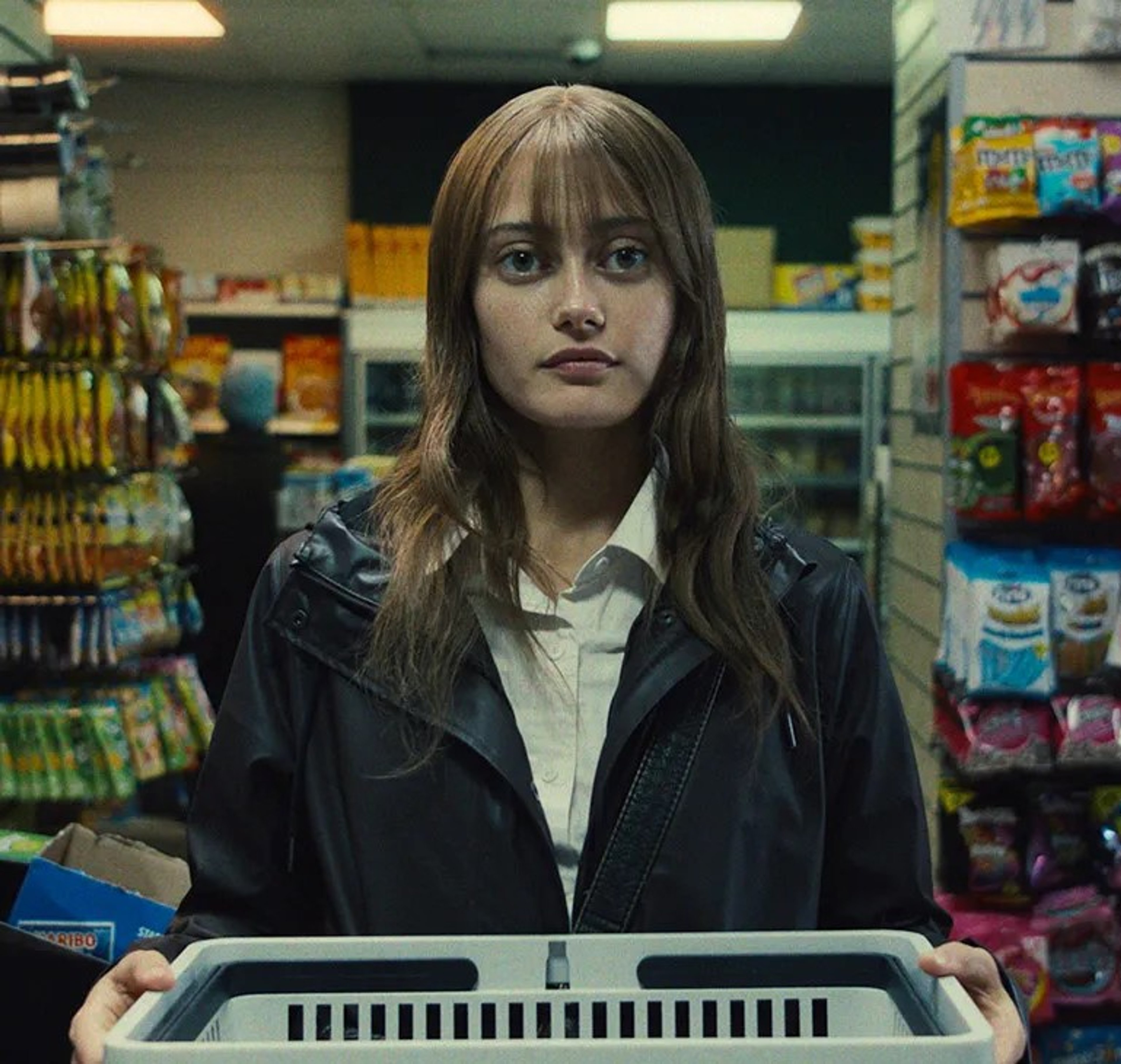A young woman with long brown hair standing in a convenience store