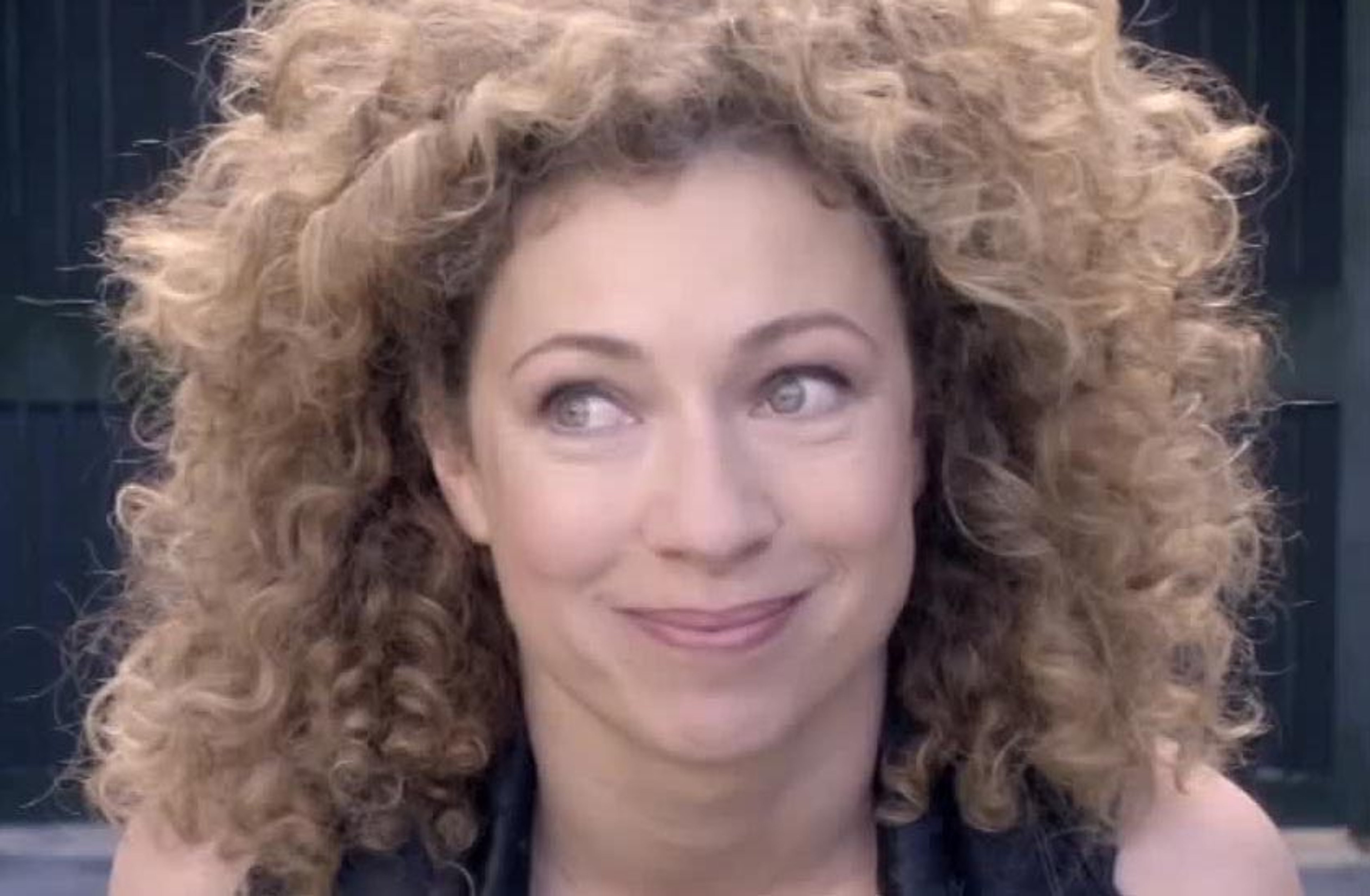 A woman with curly blonde hair and a friendly expression