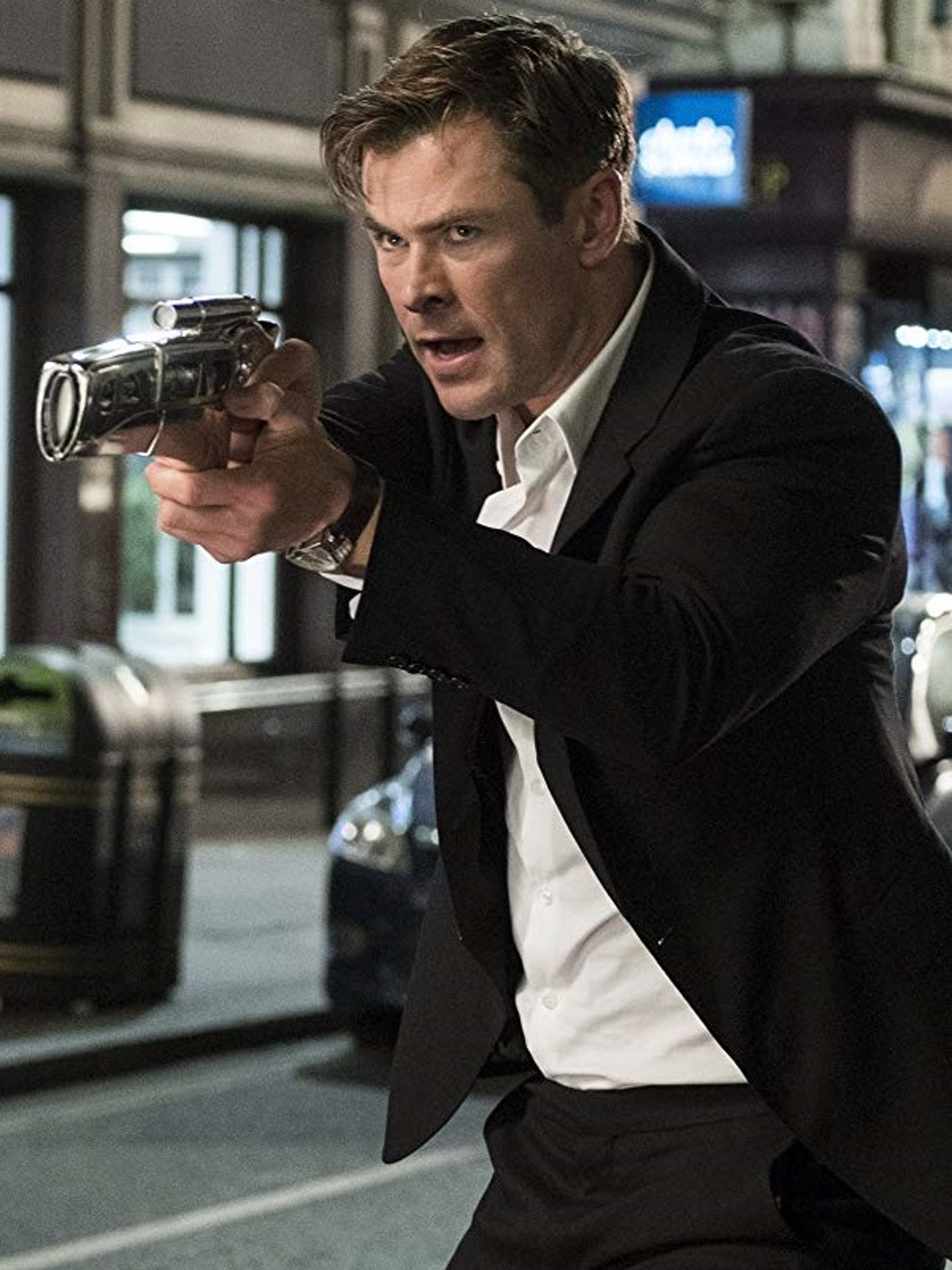 A man in a suit holding a gun