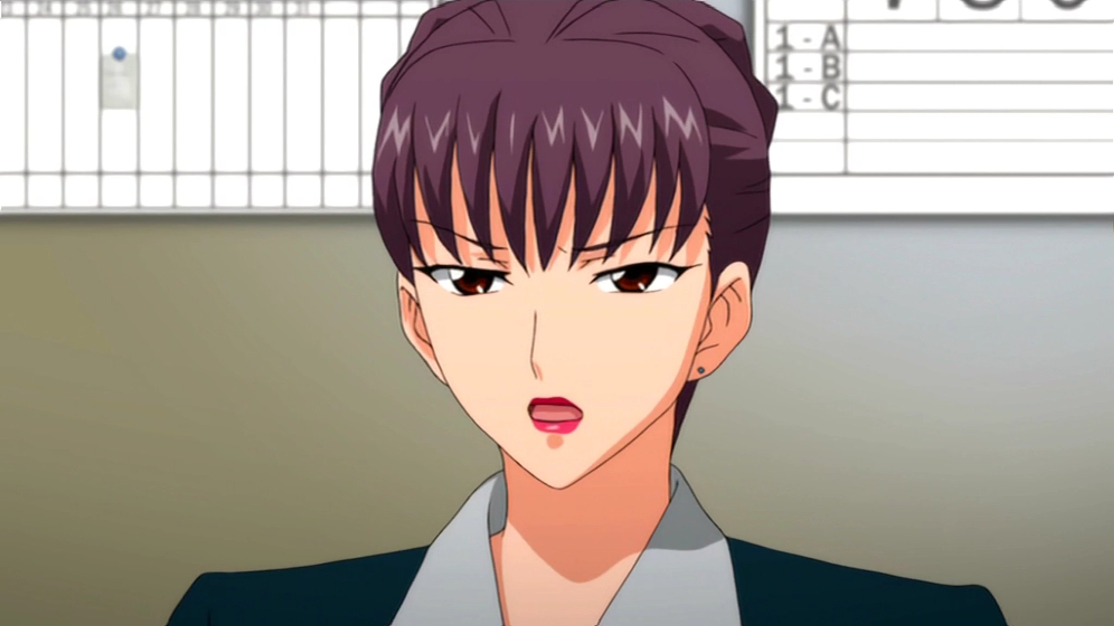 A woman with short dark hair wearing a formal gray suit, with a serious expression on her face.