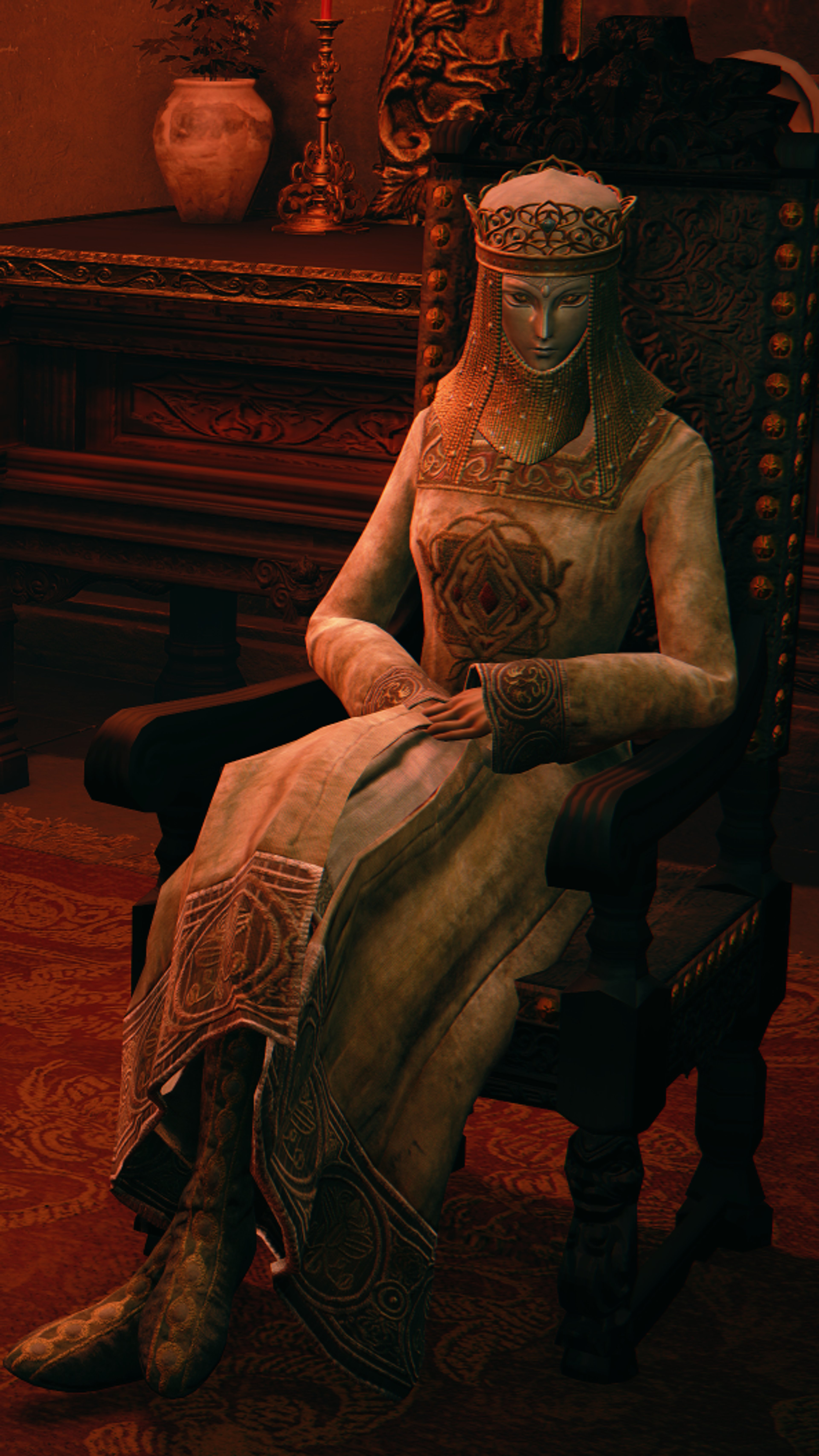 A woman with a refined and elegant appearance, seated in a chair in a dimly lit room.