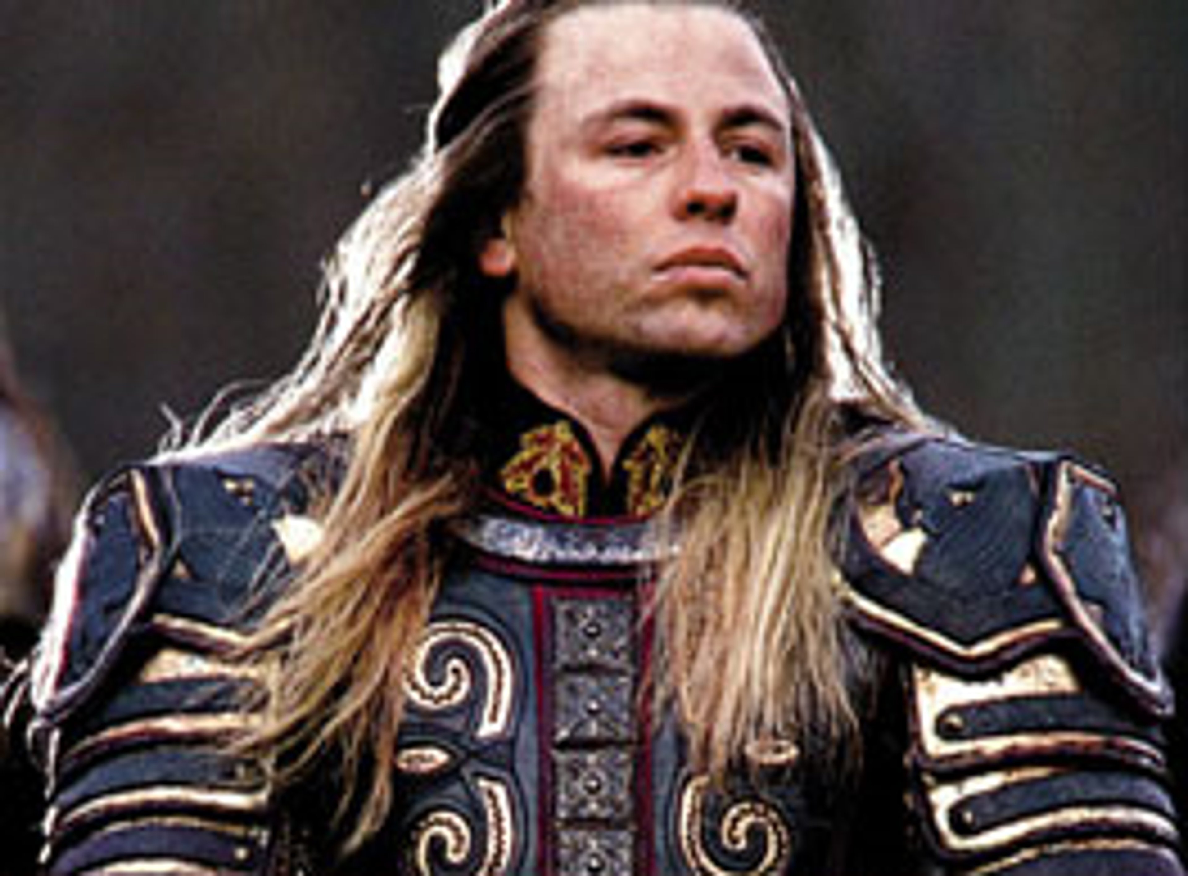 A man in ornate medieval-style armor with long blonde hair and a beard