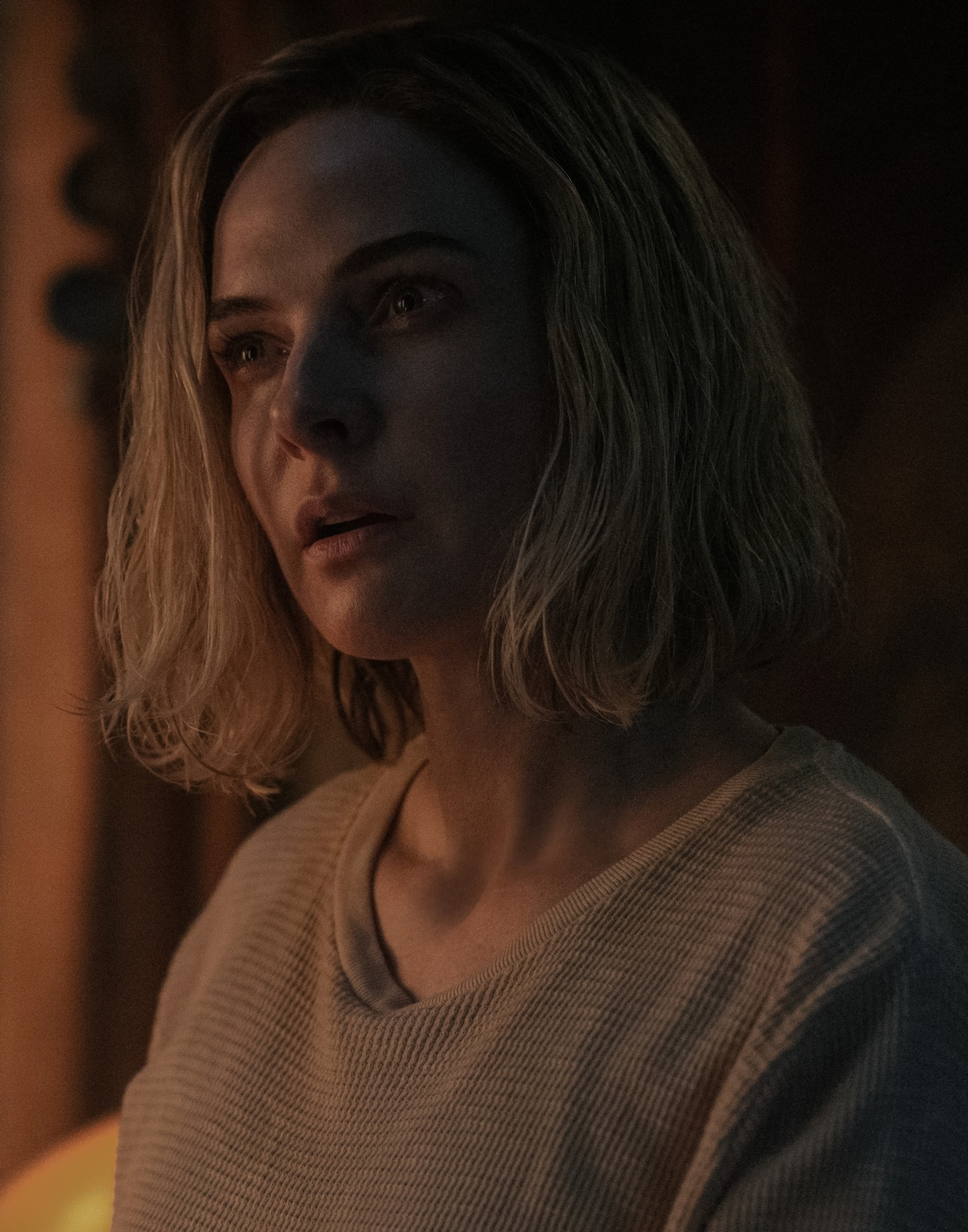 A young woman with blonde hair in a serious expression