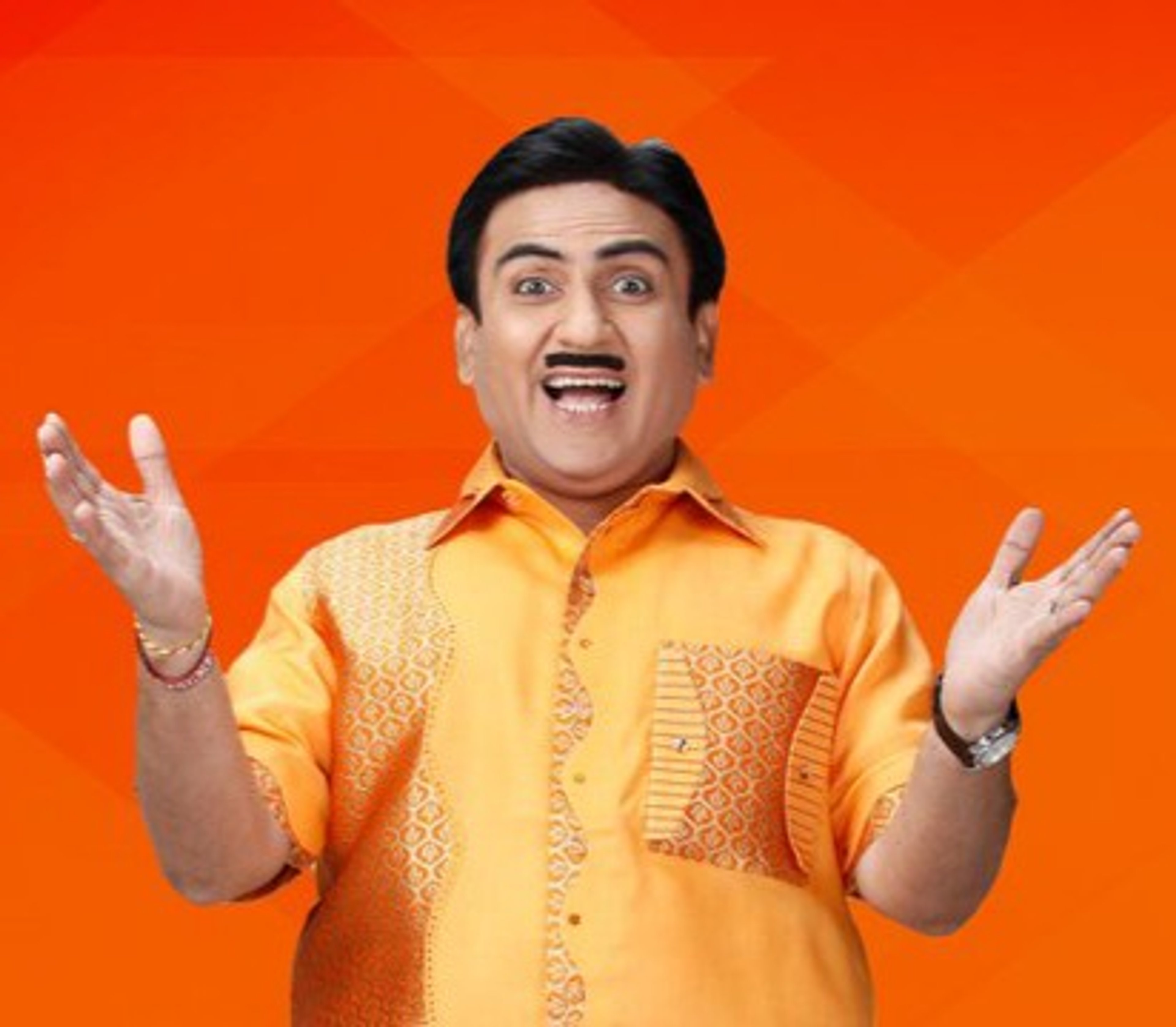 A middle-aged man with a round face, dark hair, and a mustache, wearing a bright yellow shirt and making an animated, expressive gesture.