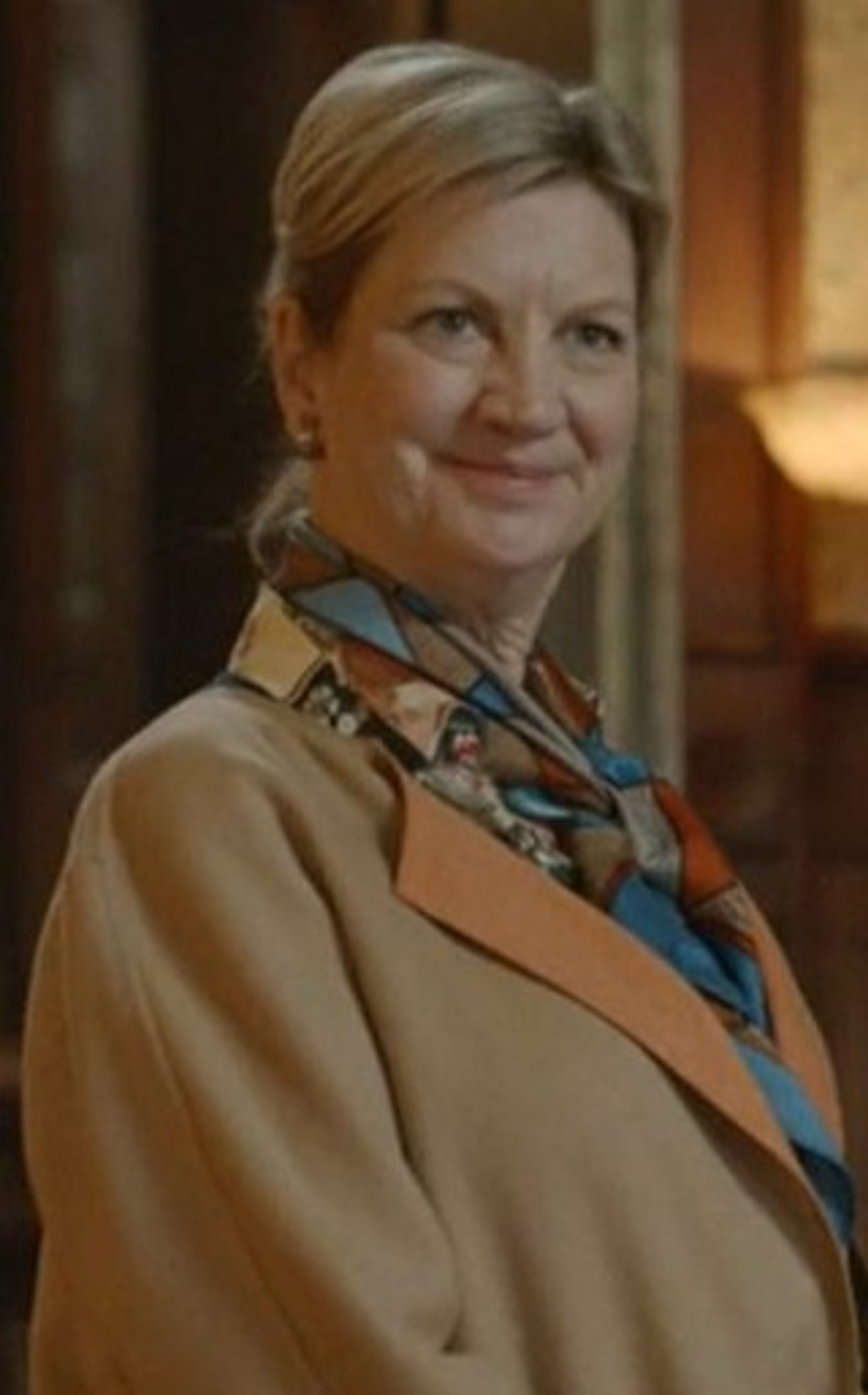 A well-dressed, middle-aged woman with blonde hair and a friendly expression.