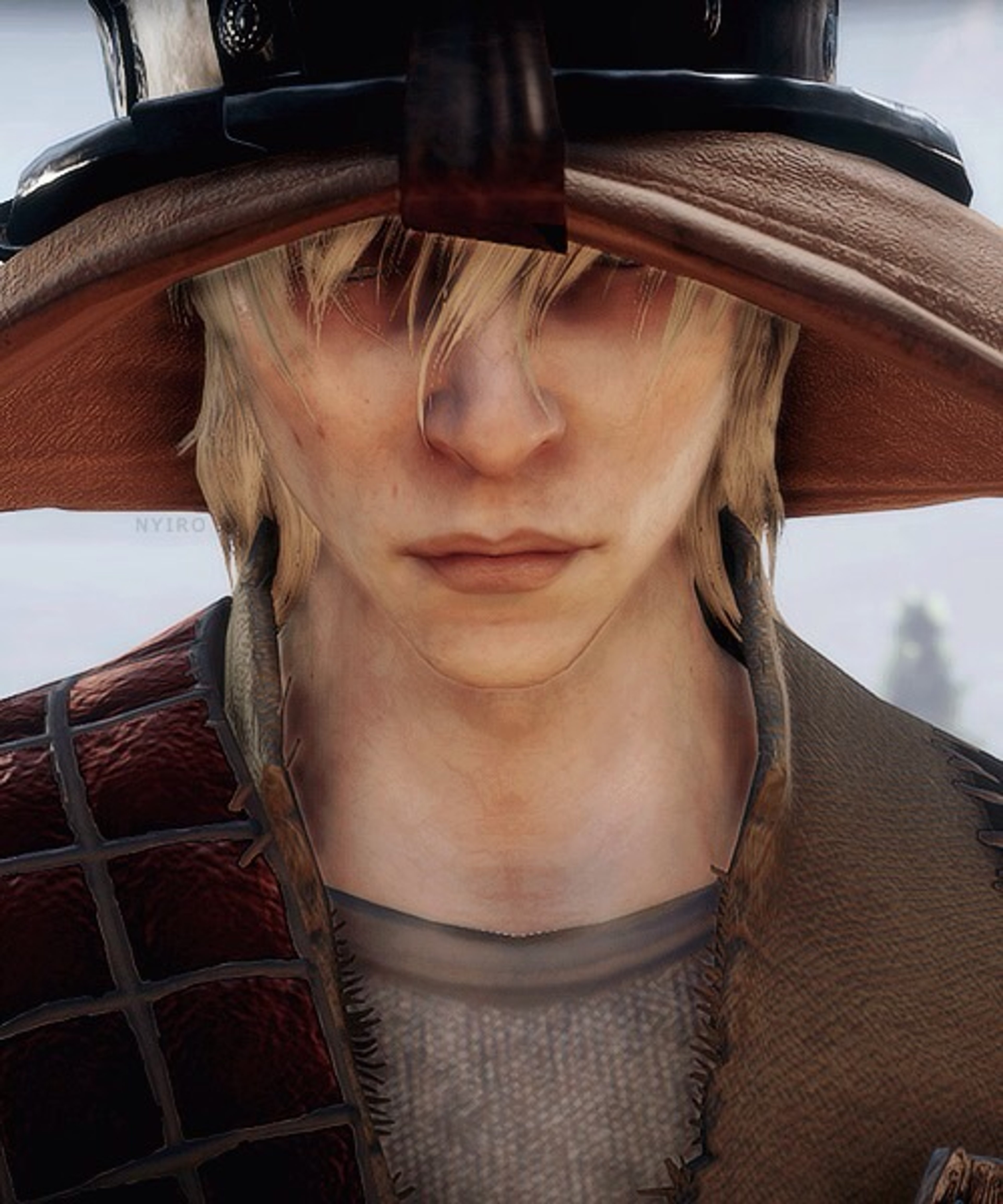 A young man with long blonde hair and a dark hat, looking pensive.