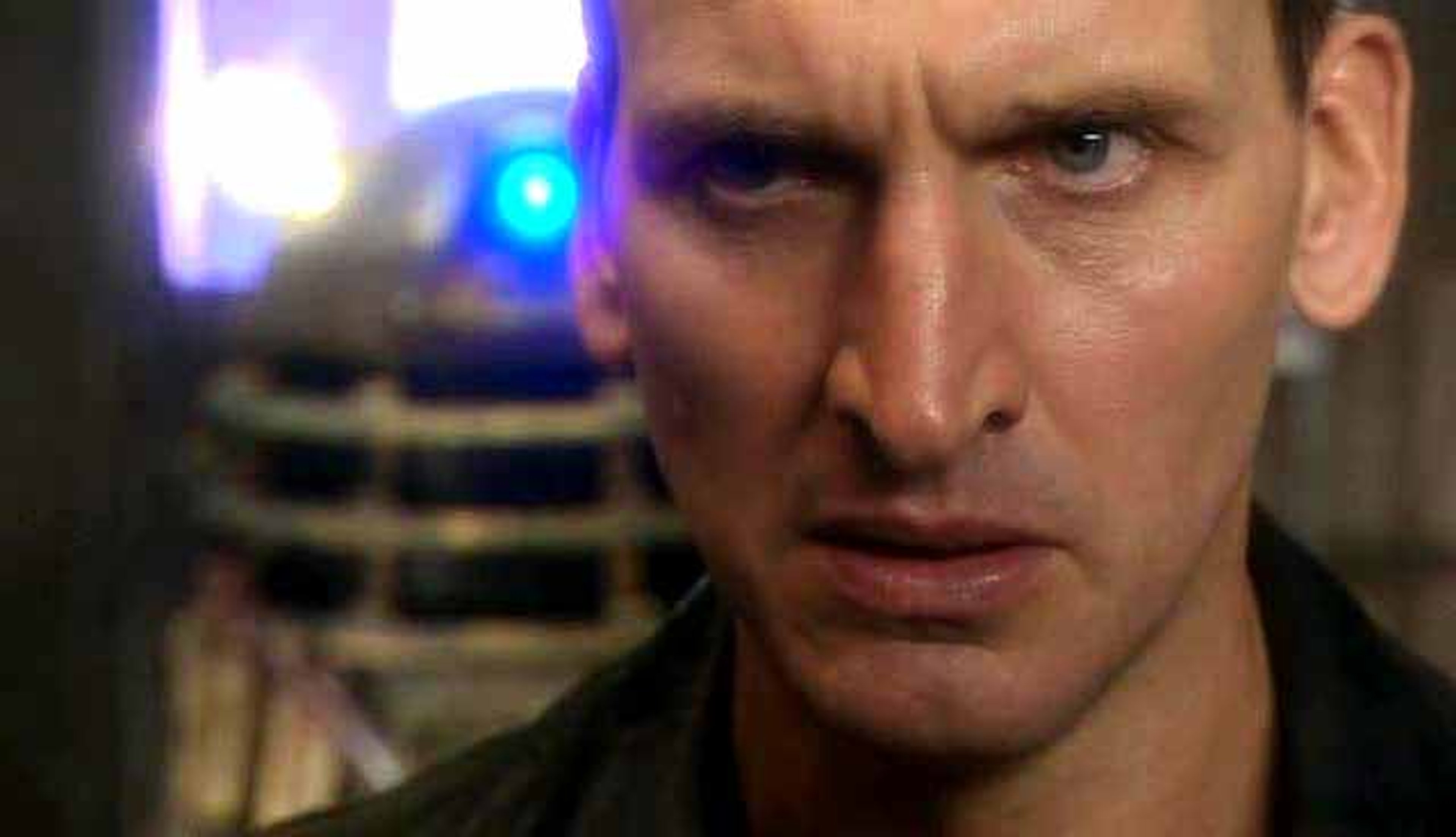 Close-up of the Ninth Doctor from Doctor Who, with a serious expression on his face.