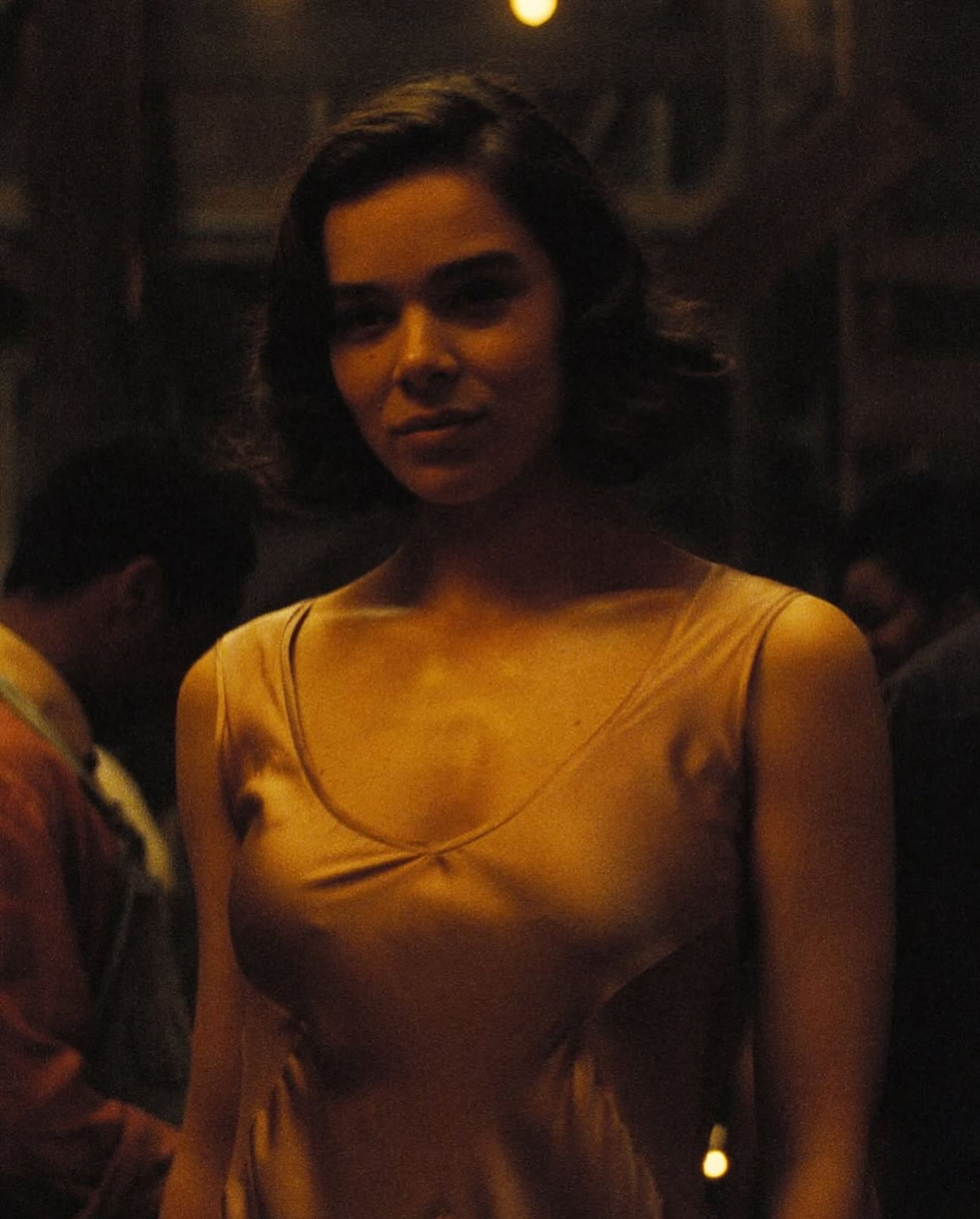 A young, mixed-race woman in an elegant period dress with a confident expression