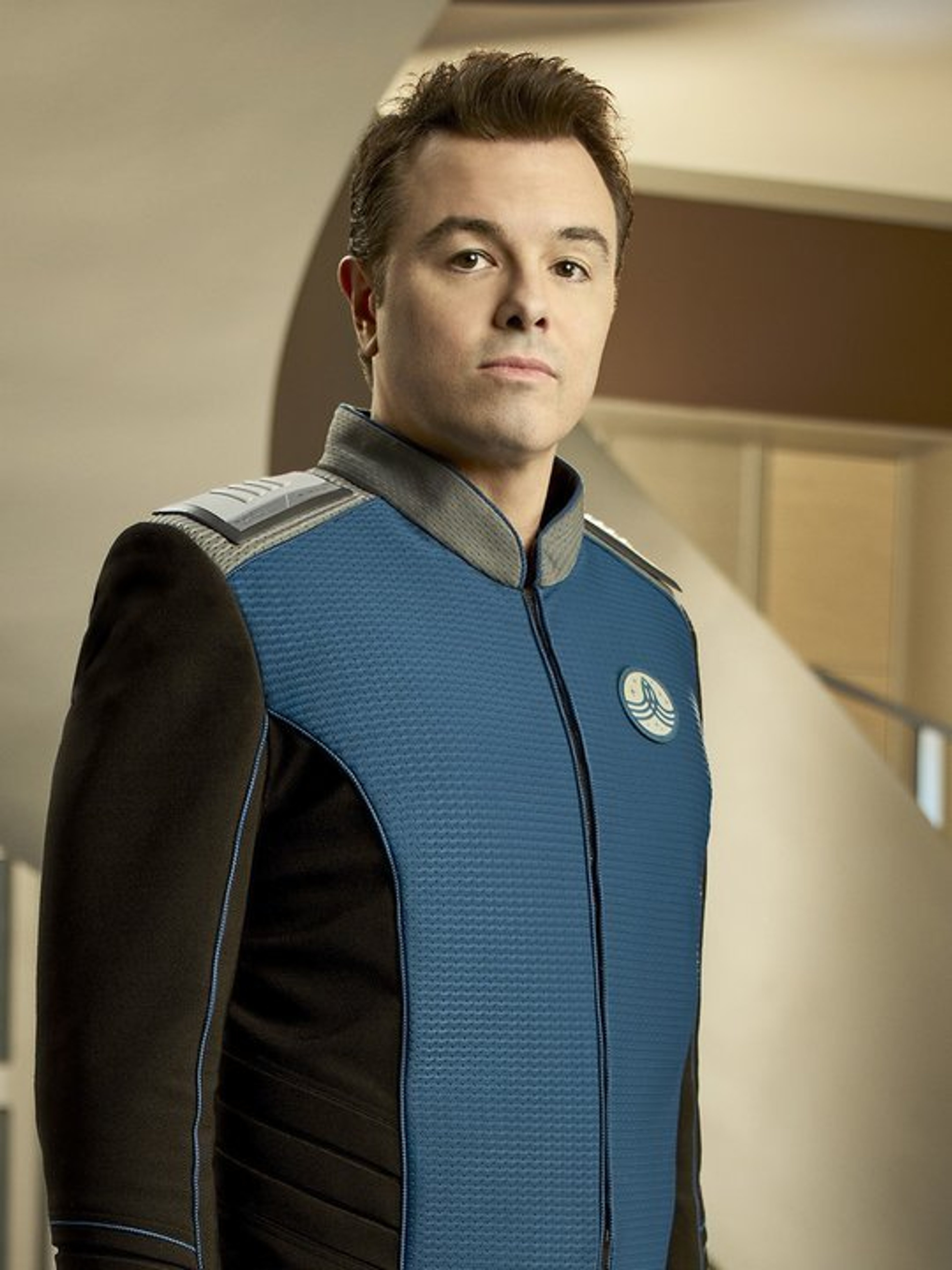 A man in a blue and black uniform with a Starfleet-like insignia on the chest