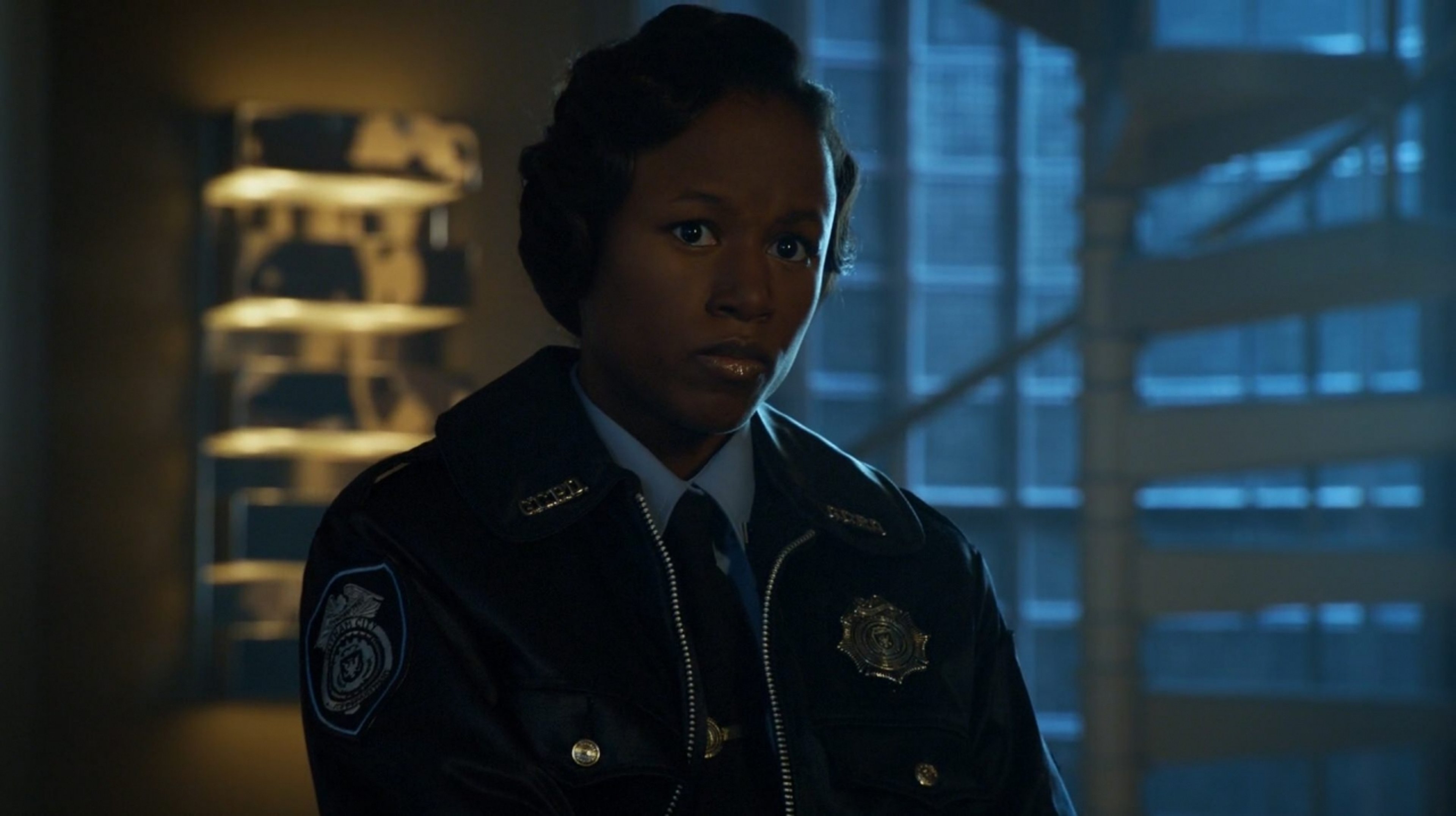 A young, serious-looking police officer in a Gotham City police uniform