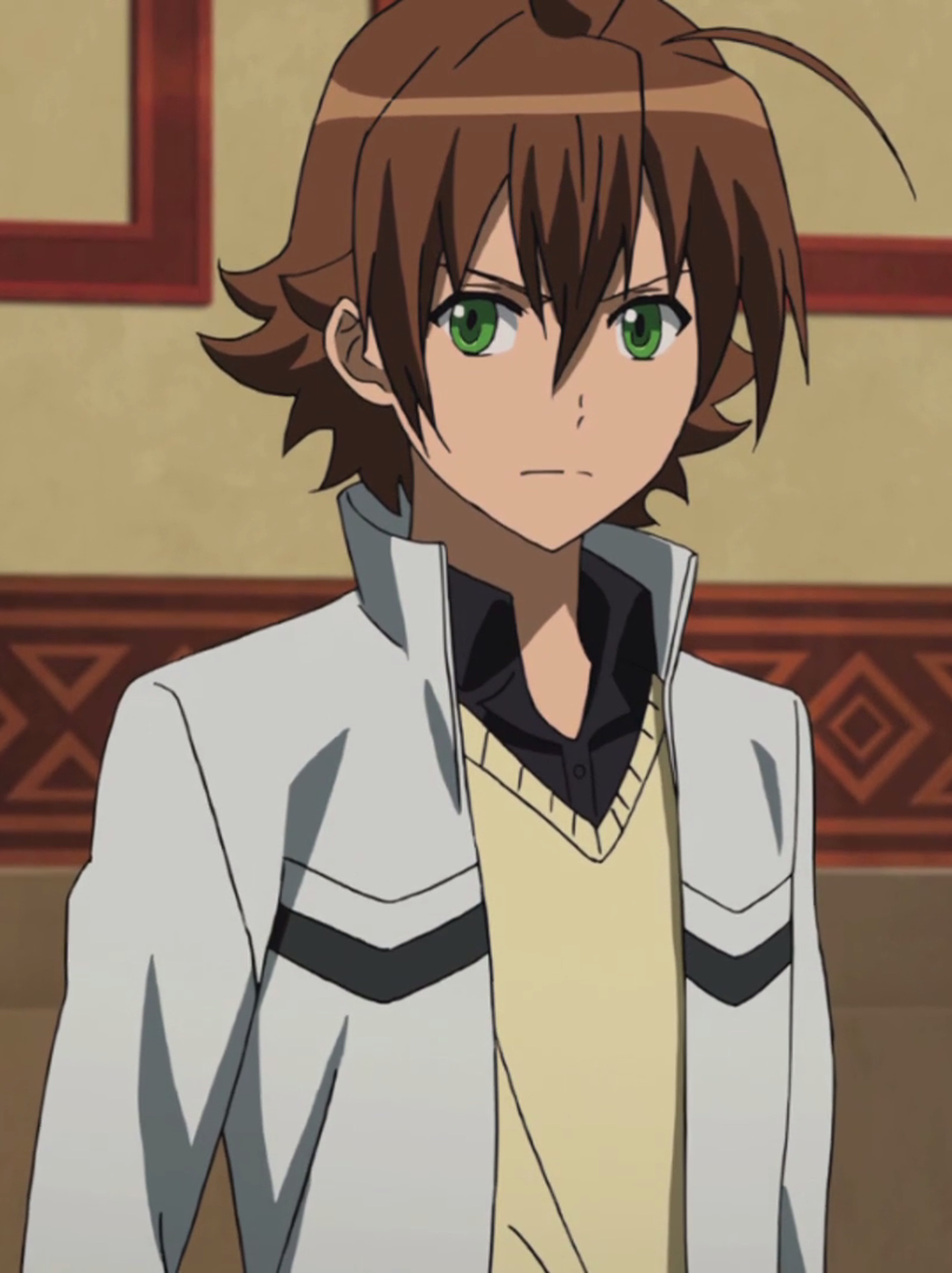 A young man with short brown hair and green eyes wearing a white shirt with black accents