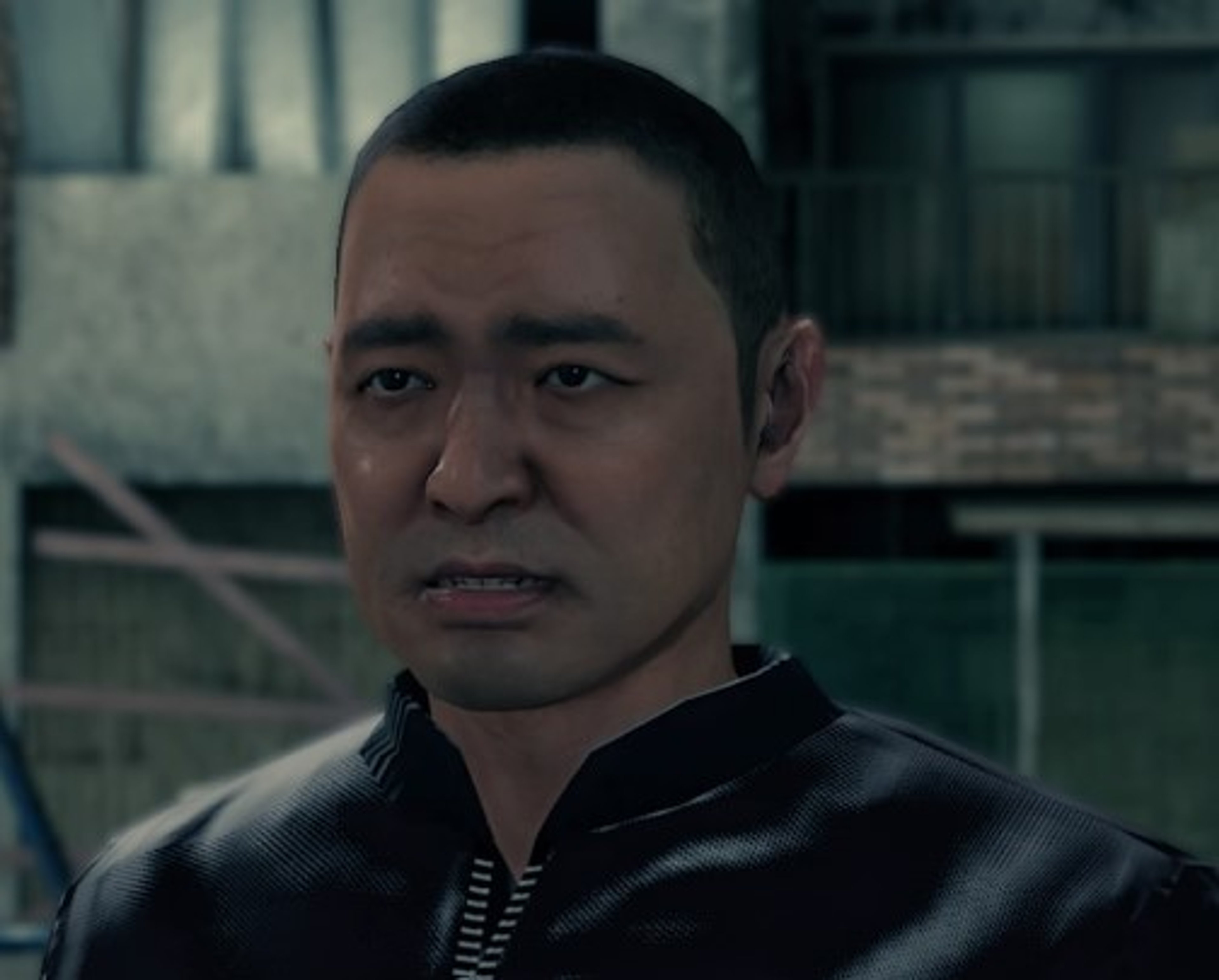A middle-aged Asian man with a serious expression