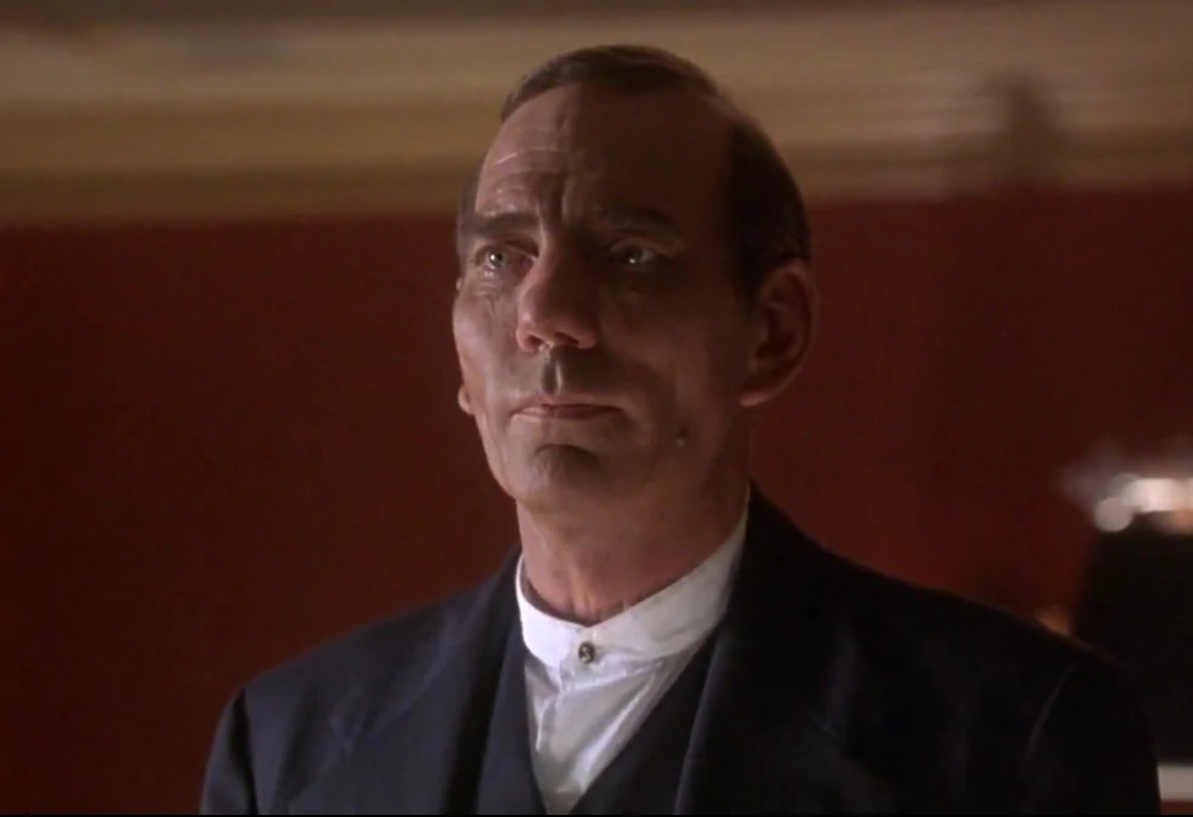 A well-dressed, middle-aged man with a serious expression