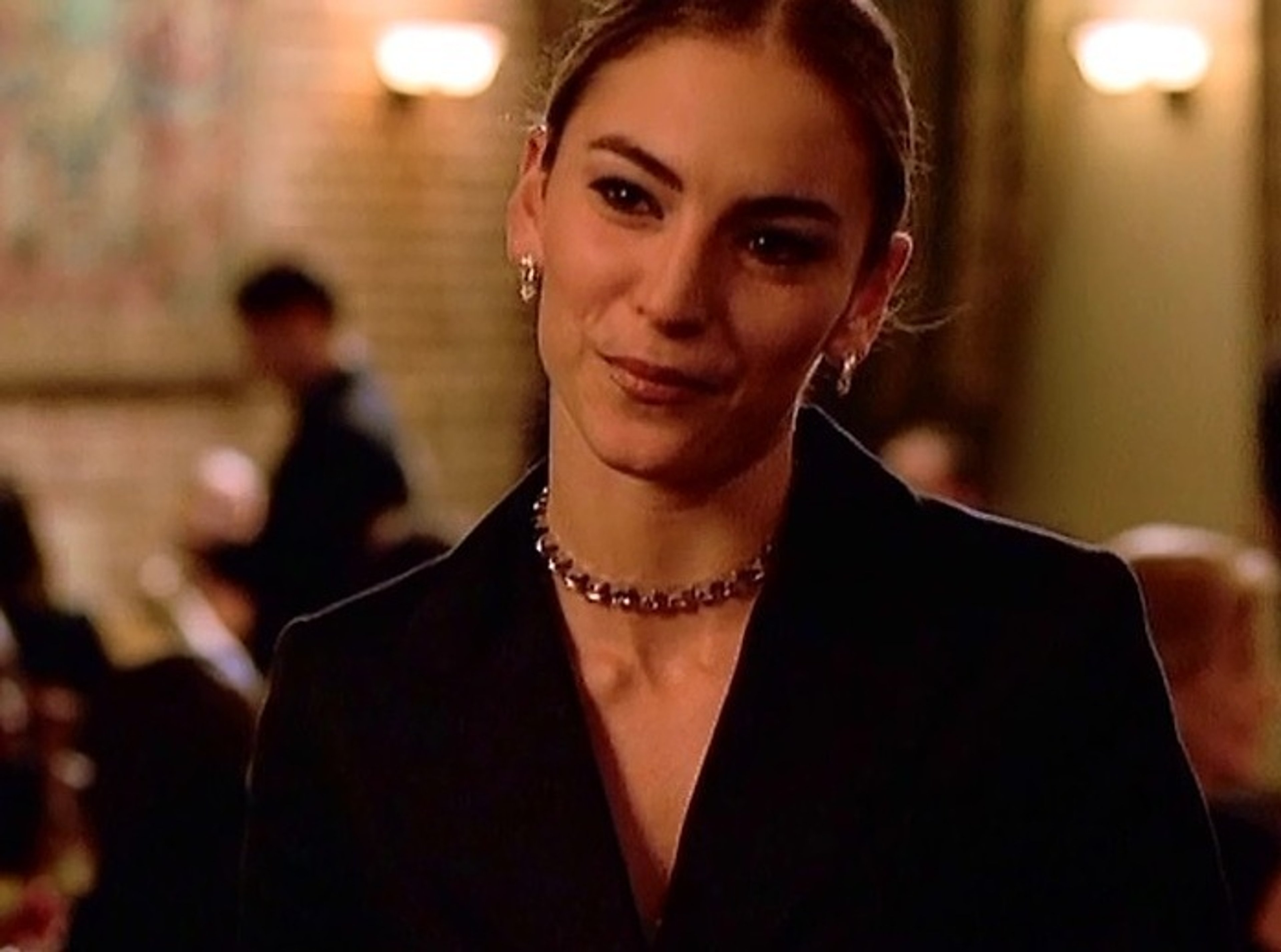 A woman with dark hair wearing a black dress in a formal setting