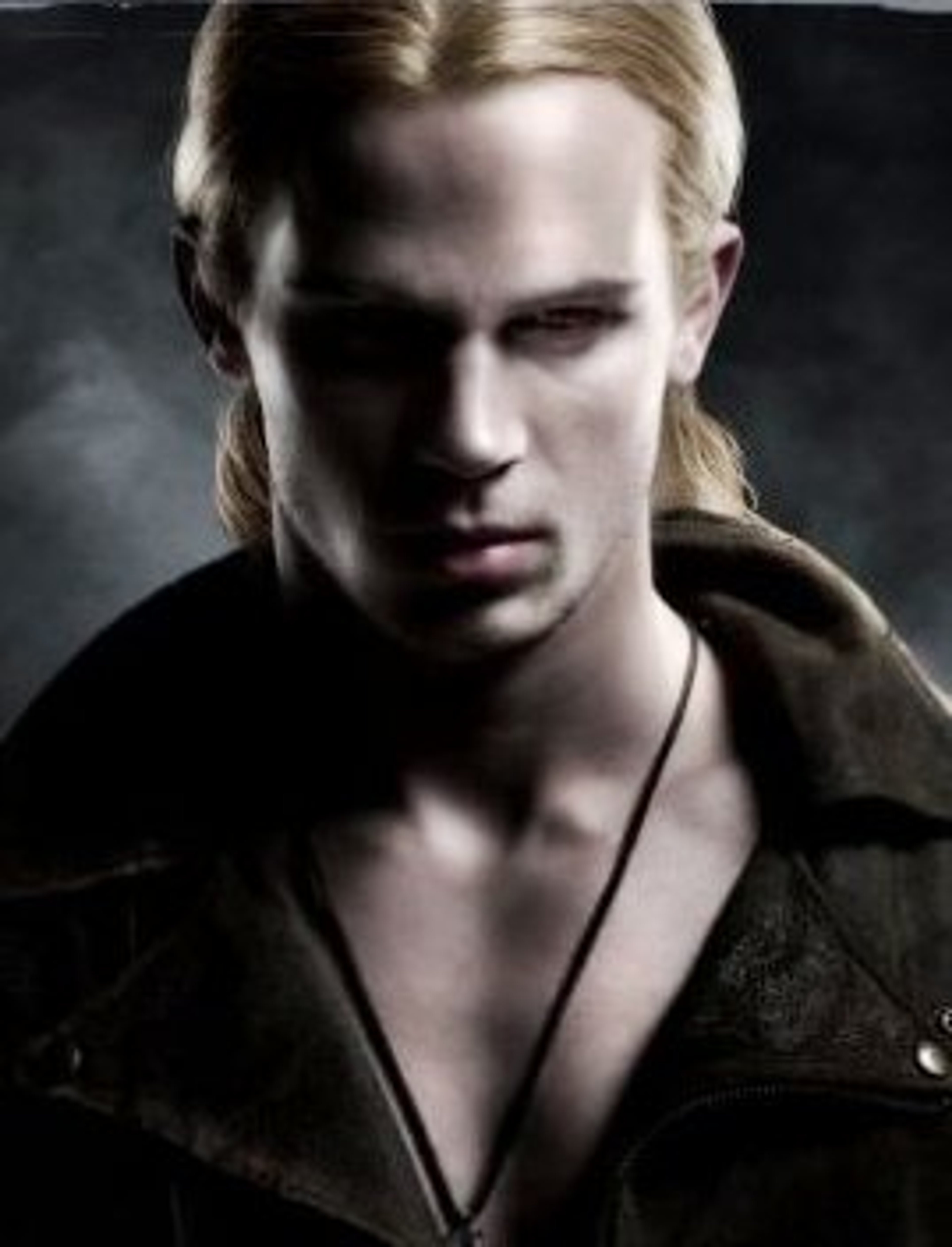 A serious-looking young man with long blonde hair and piercing blue eyes, wearing a dark leather jacket.