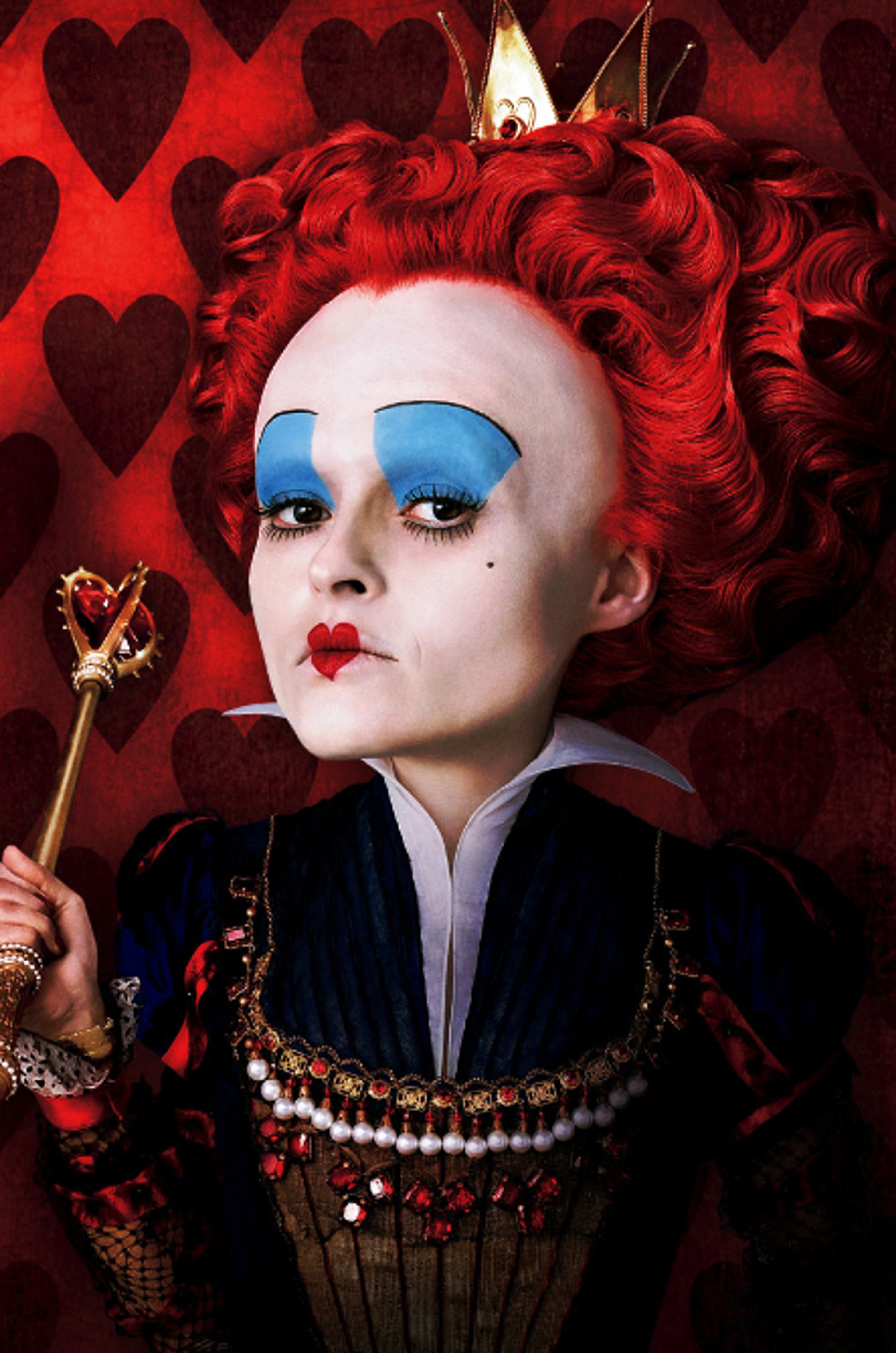 A woman with an abnormally large head wearing an elaborate black and gold costume, holding a scepter and looking angry