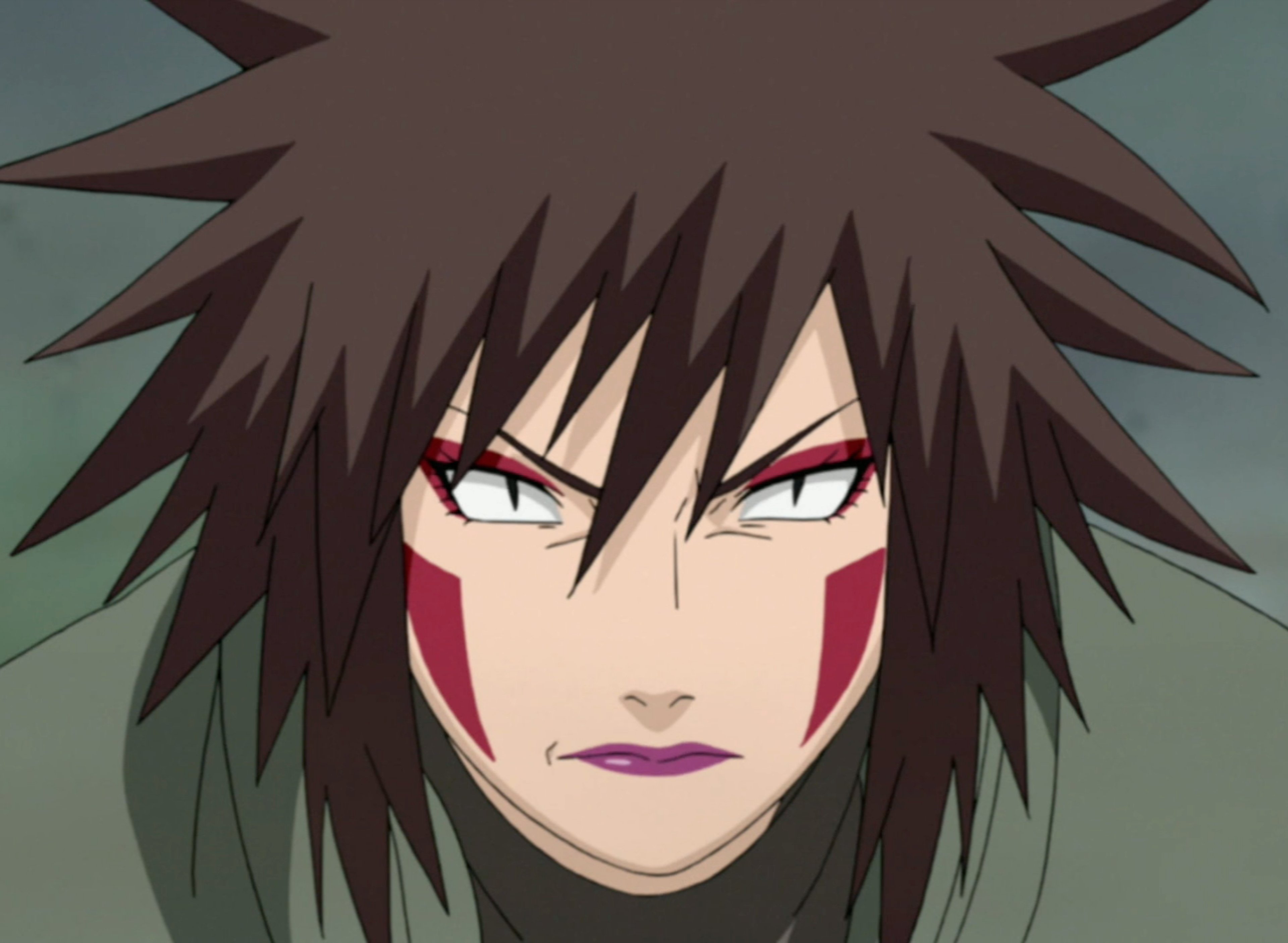 A fierce-looking woman with wild brown hair and intense eyes, wearing a dark ninja-style outfit.