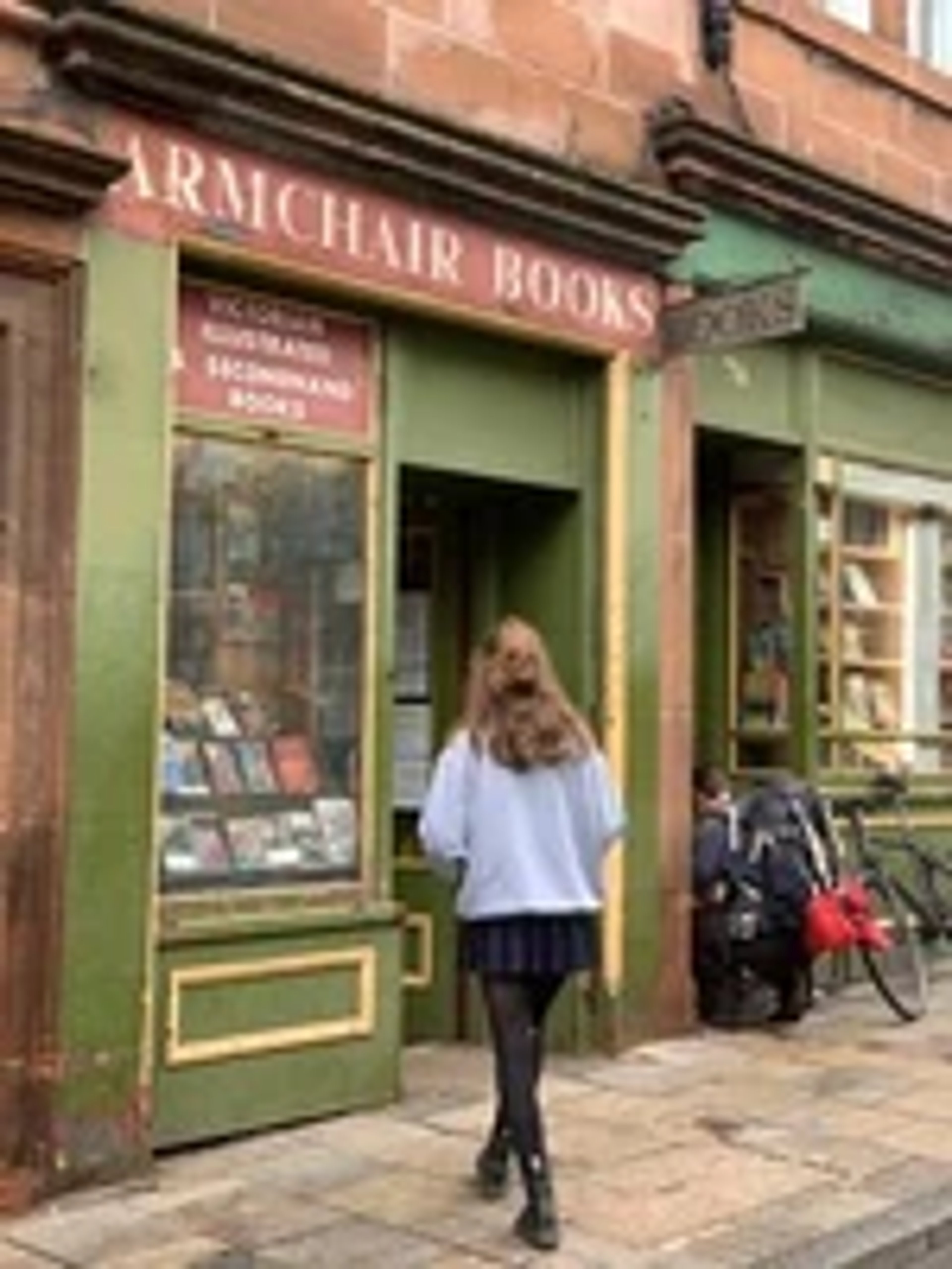 A woman standing in the doorway of a bookstore