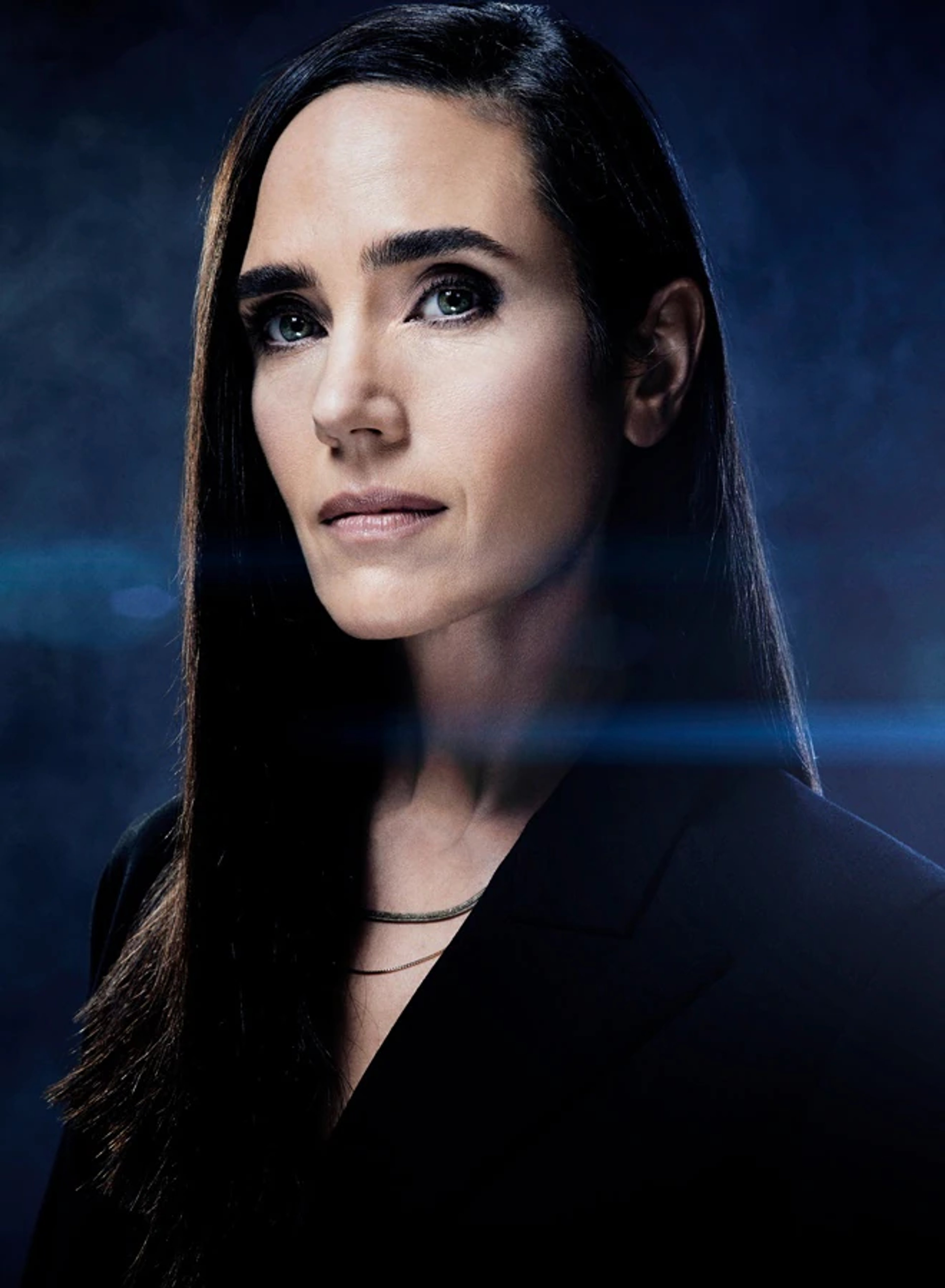 A close-up portrait of a serious-looking woman with long, dark hair