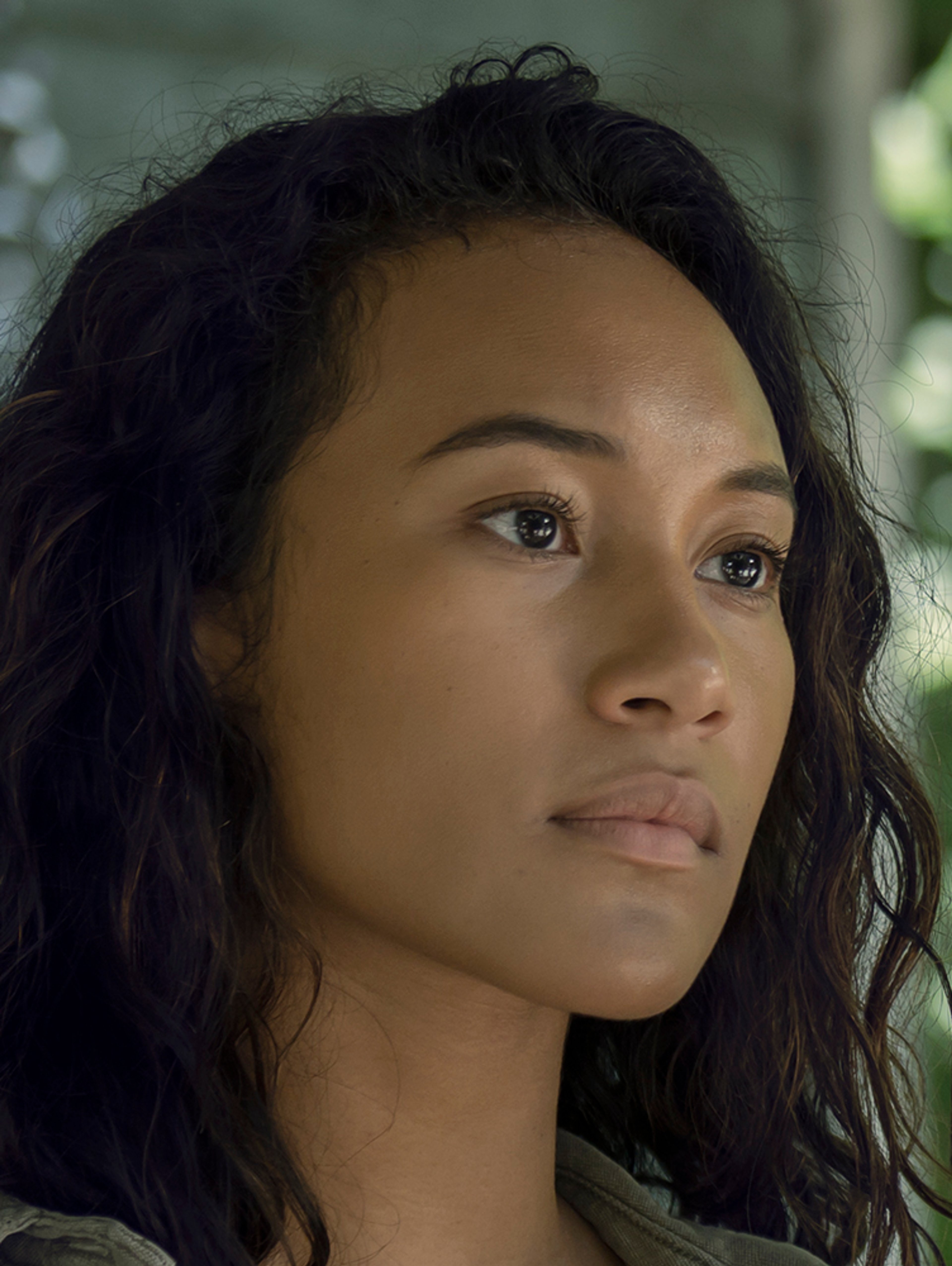 A young woman with dark hair and a serious expression