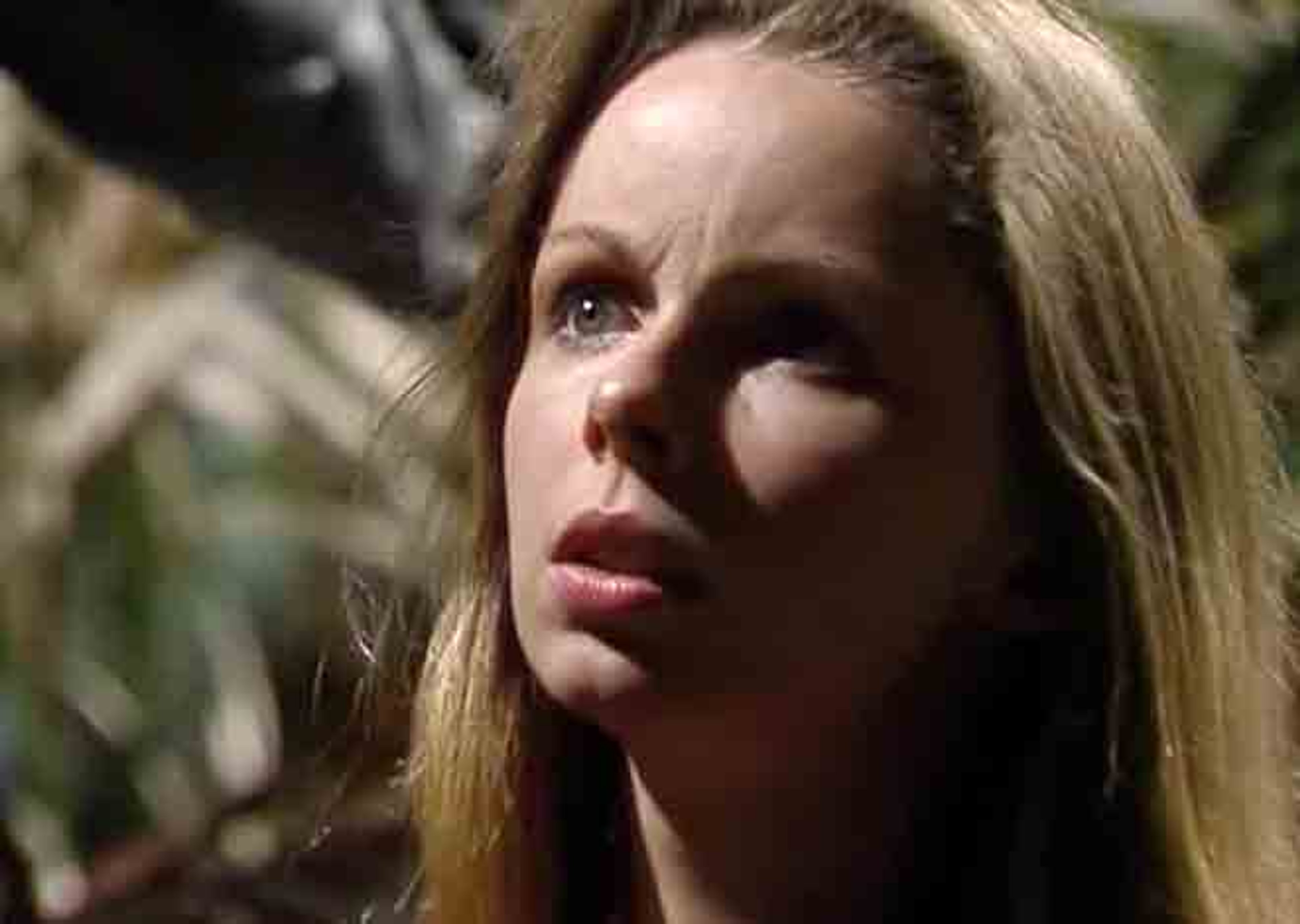 A young woman with long blonde hair and a serious expression