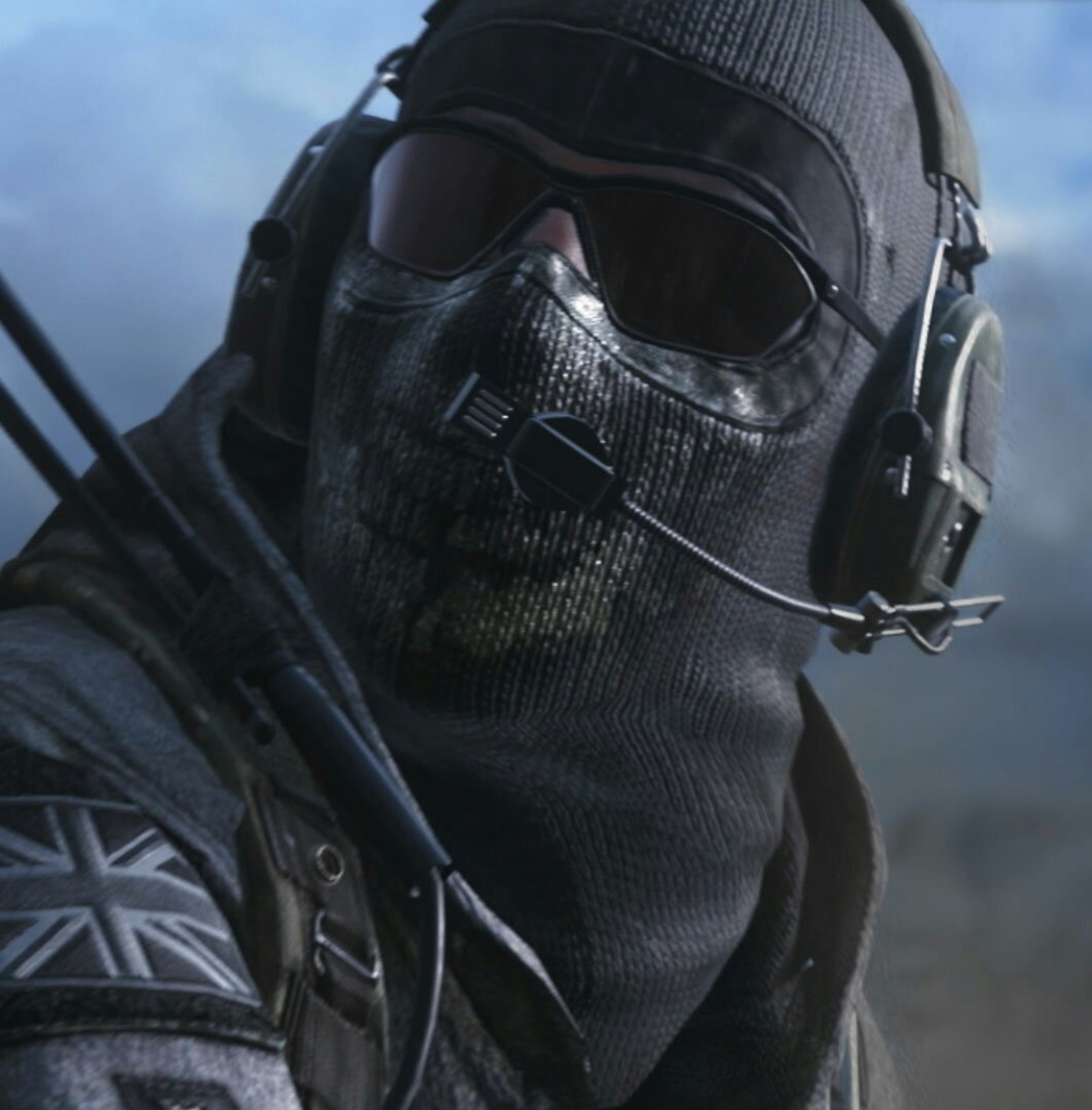 A heavily armed and armored special forces operator wearing a skull-patterned balaclava