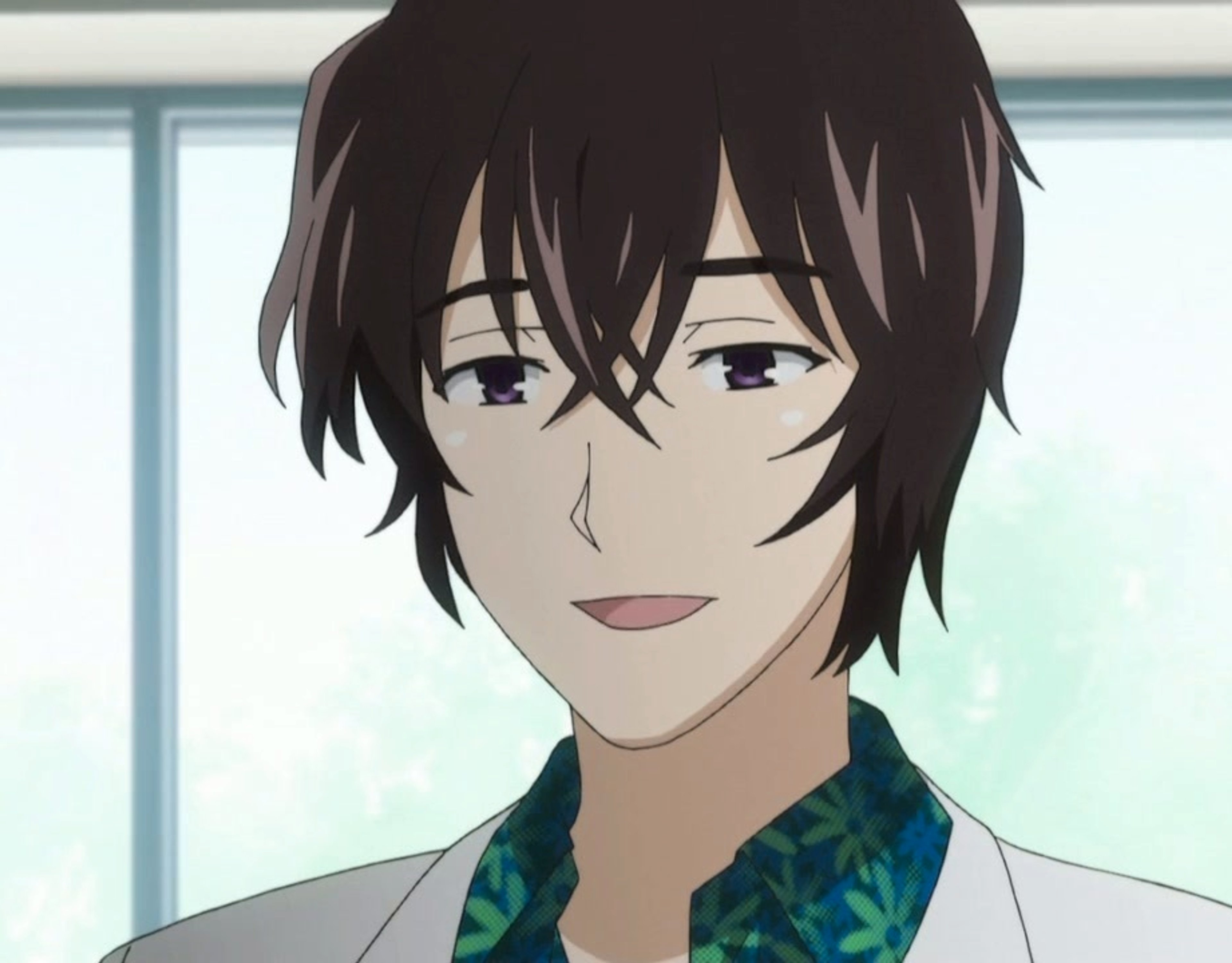 A young man with short dark hair wearing a patterned shirt