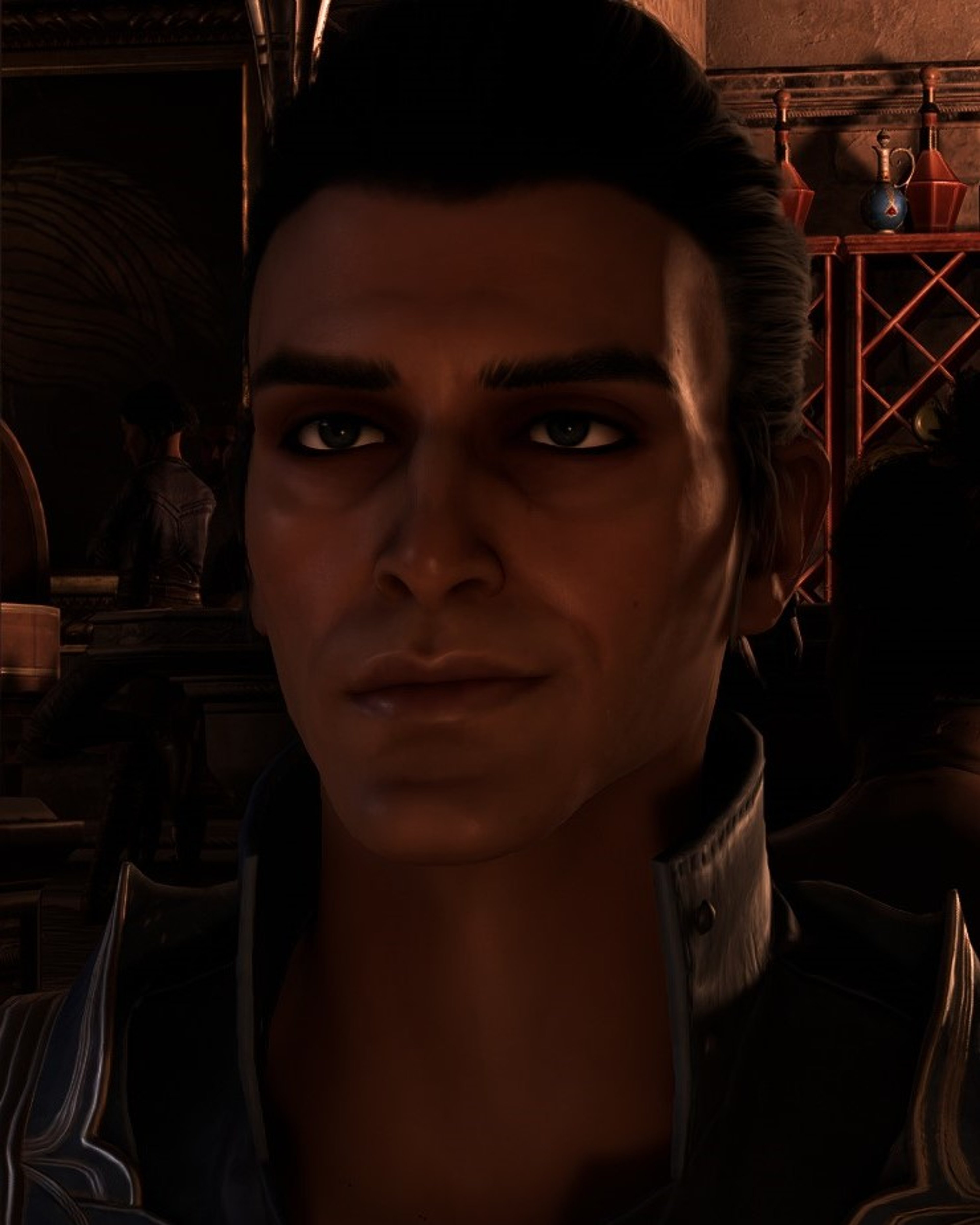 A man with dark hair and intense eyes, wearing a high-collared shirt or jacket.