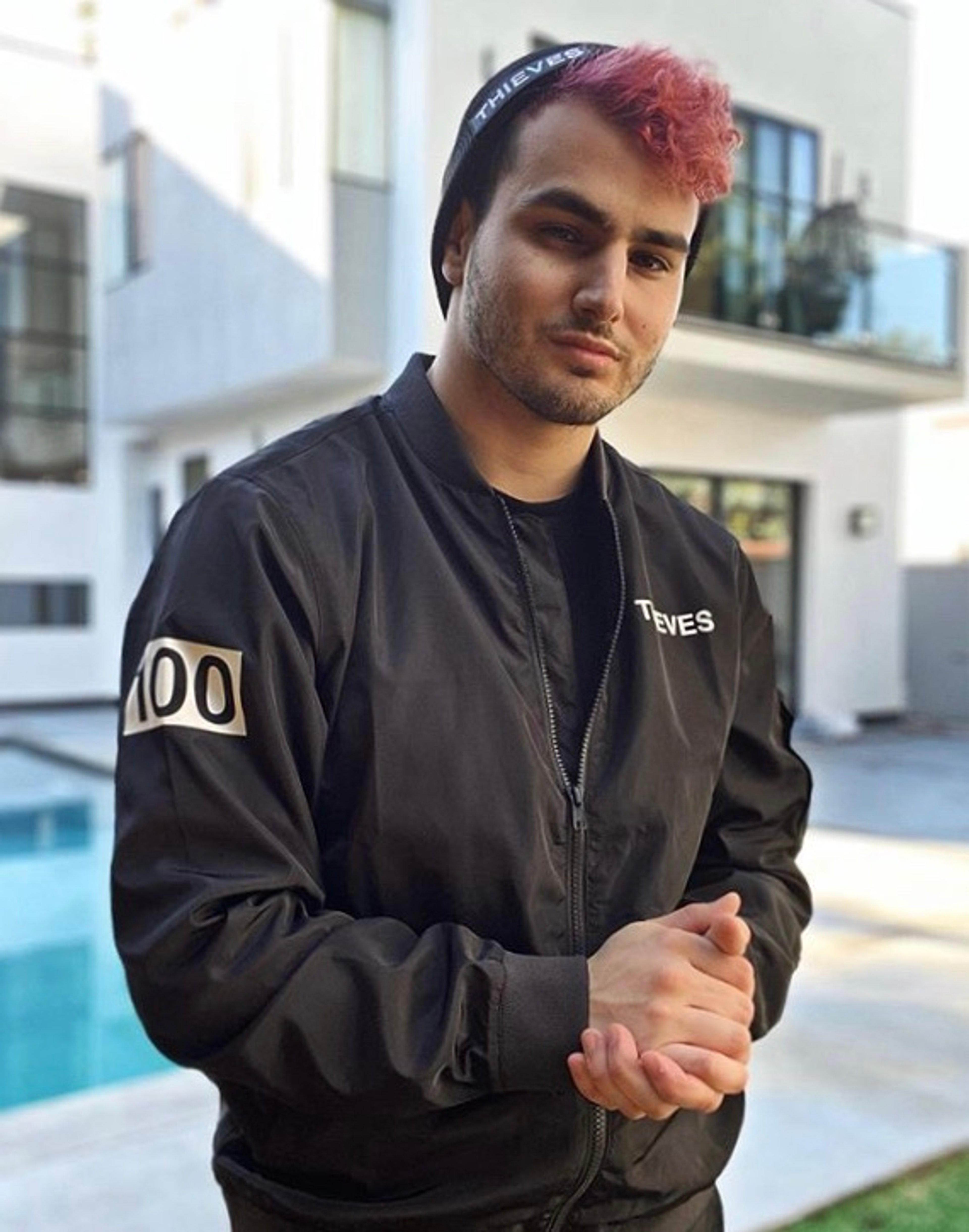 A young man with dark hair wearing a black jacket