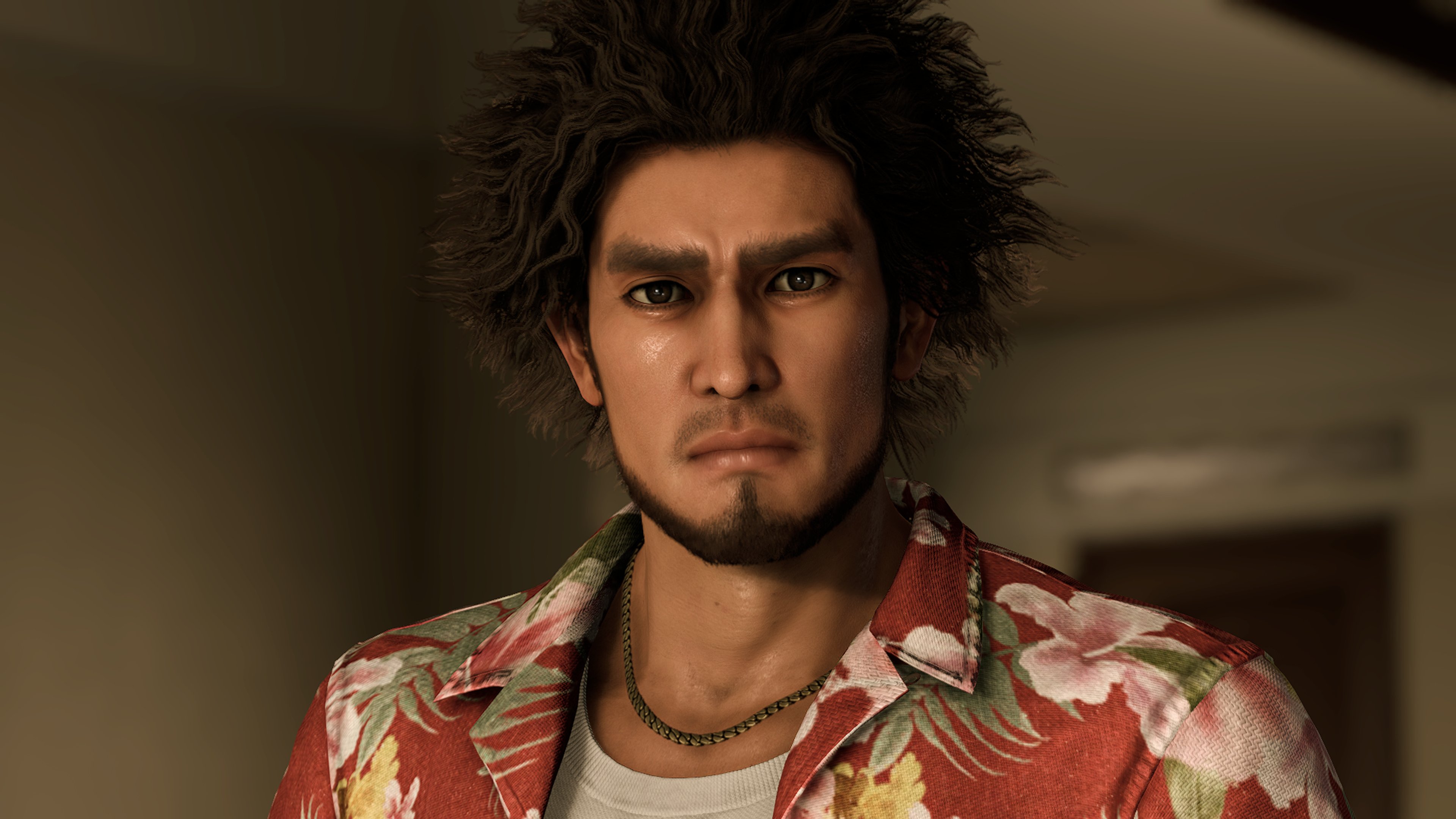 A man with spiky dark hair wearing a colorful, patterned shirt