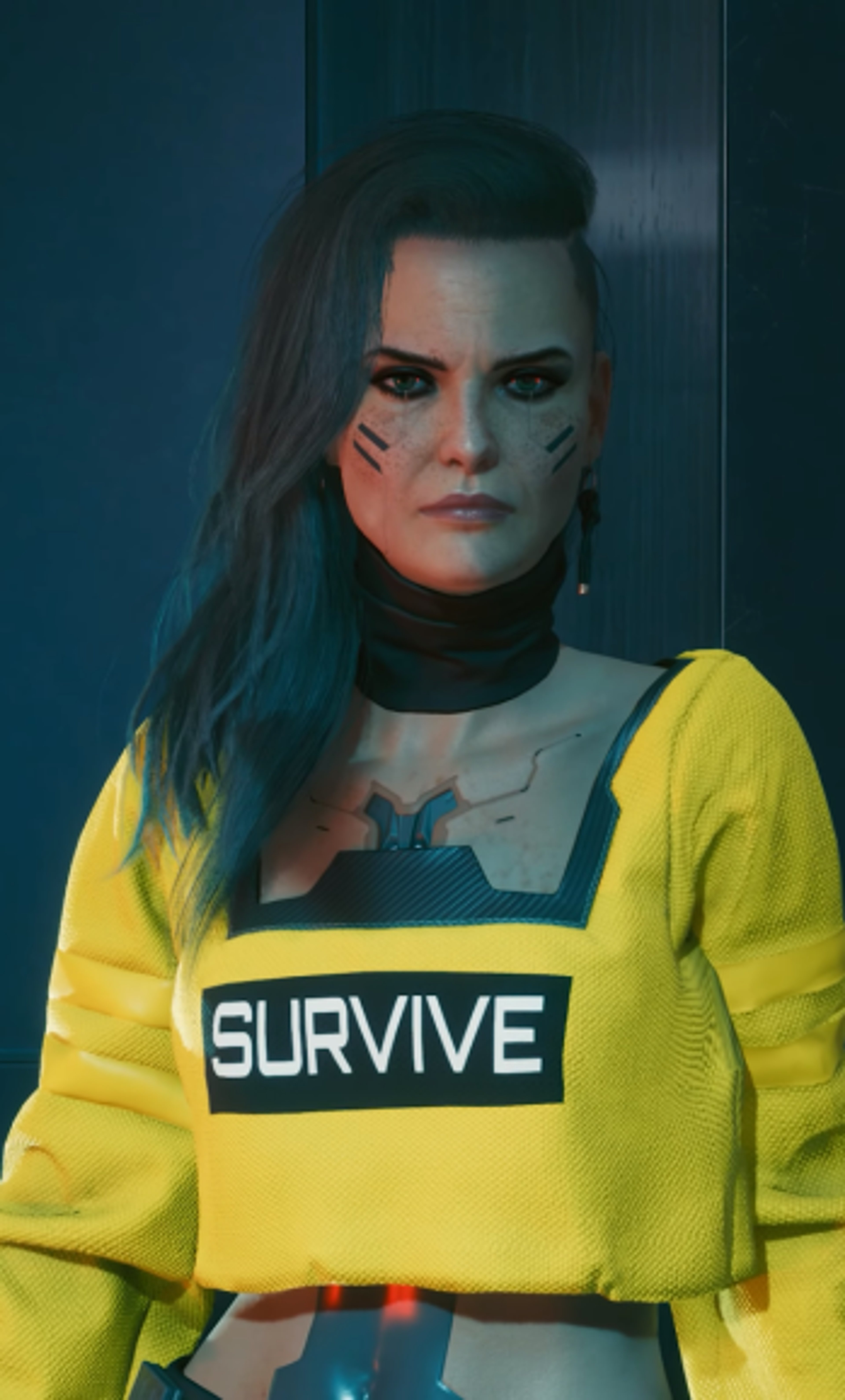 A woman in a yellow 'SURVIVE' sweater with a serious expression