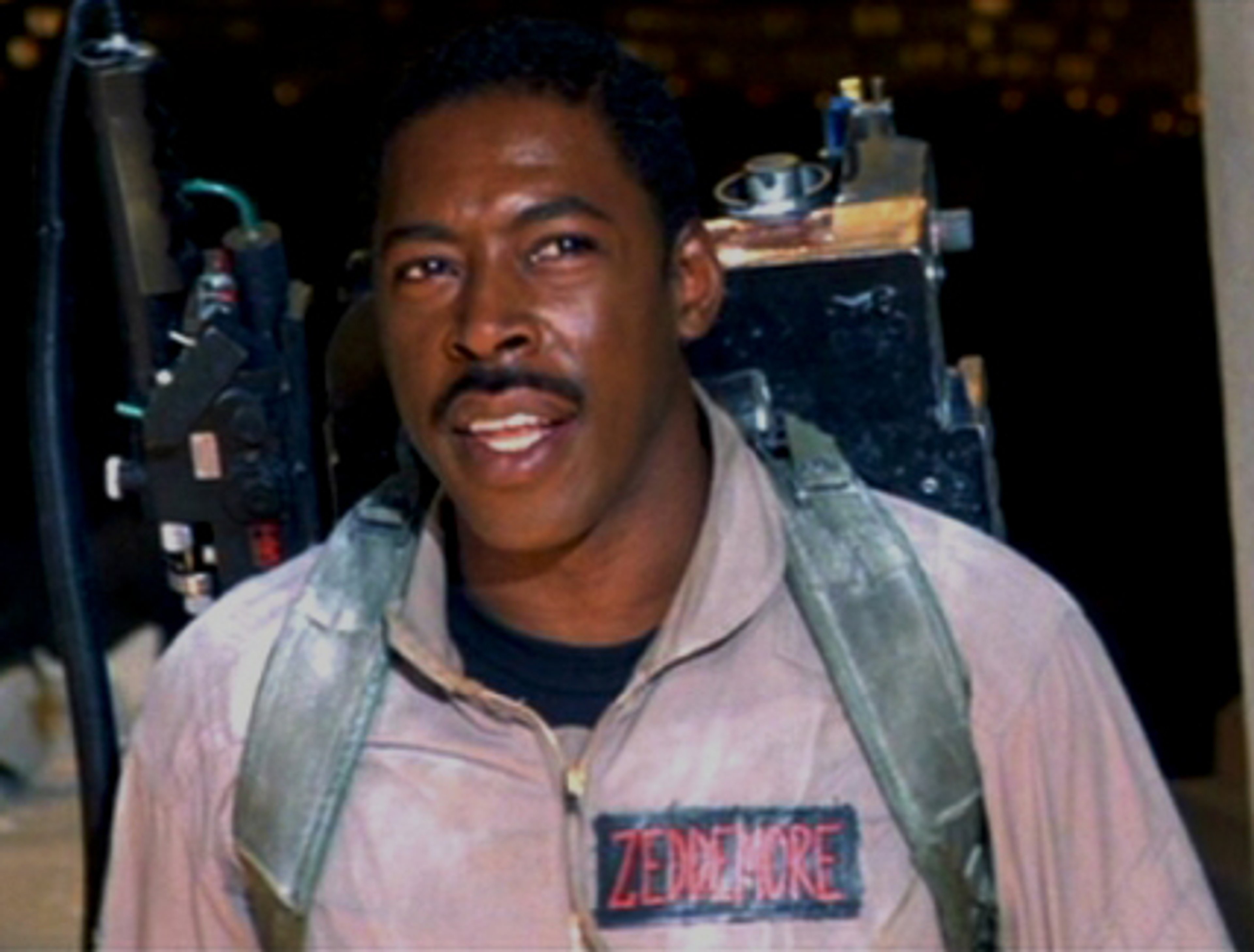 A man in a Ghostbusters jumpsuit smiling at the camera