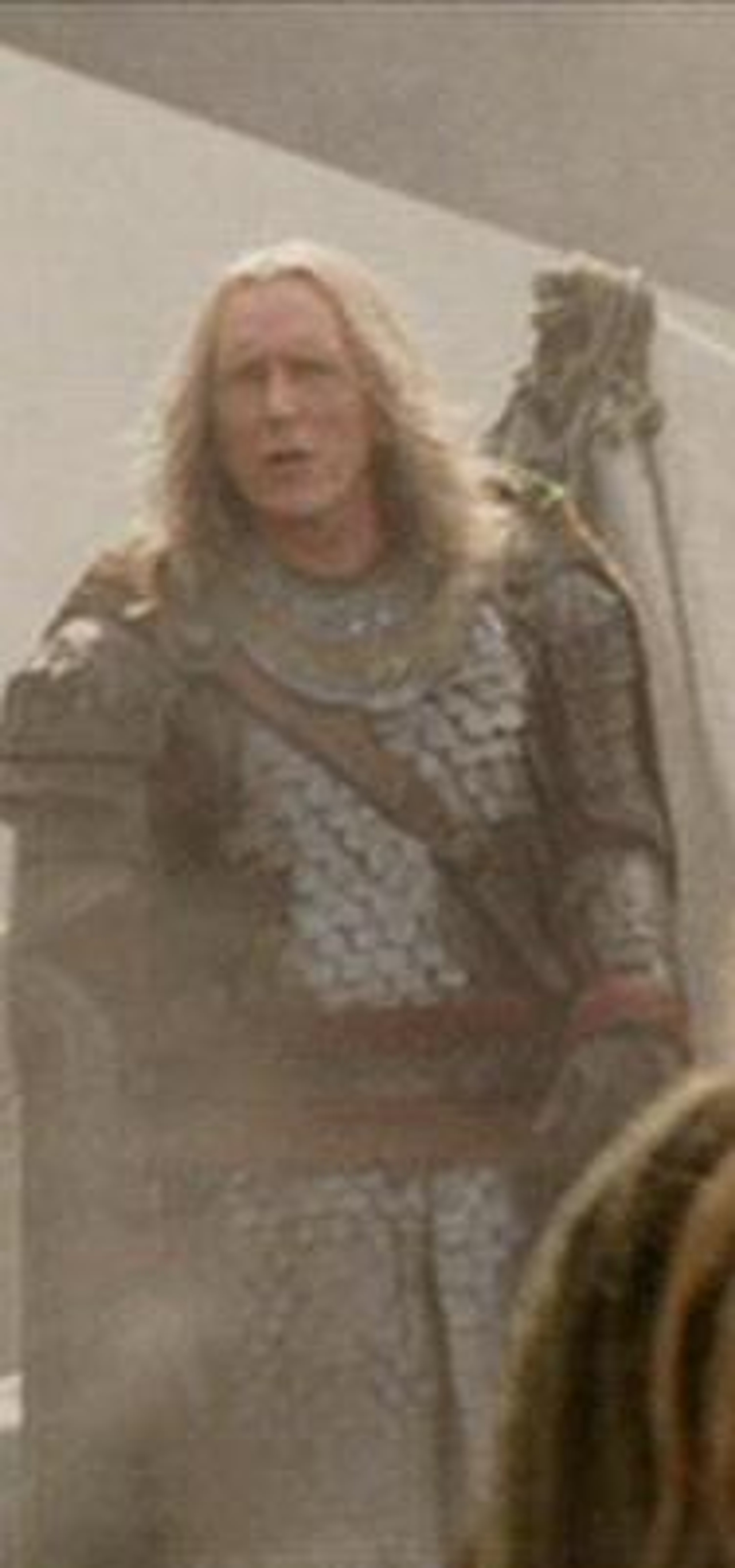 A grizzled, battle-hardened warrior in fur-lined armor and a cloak