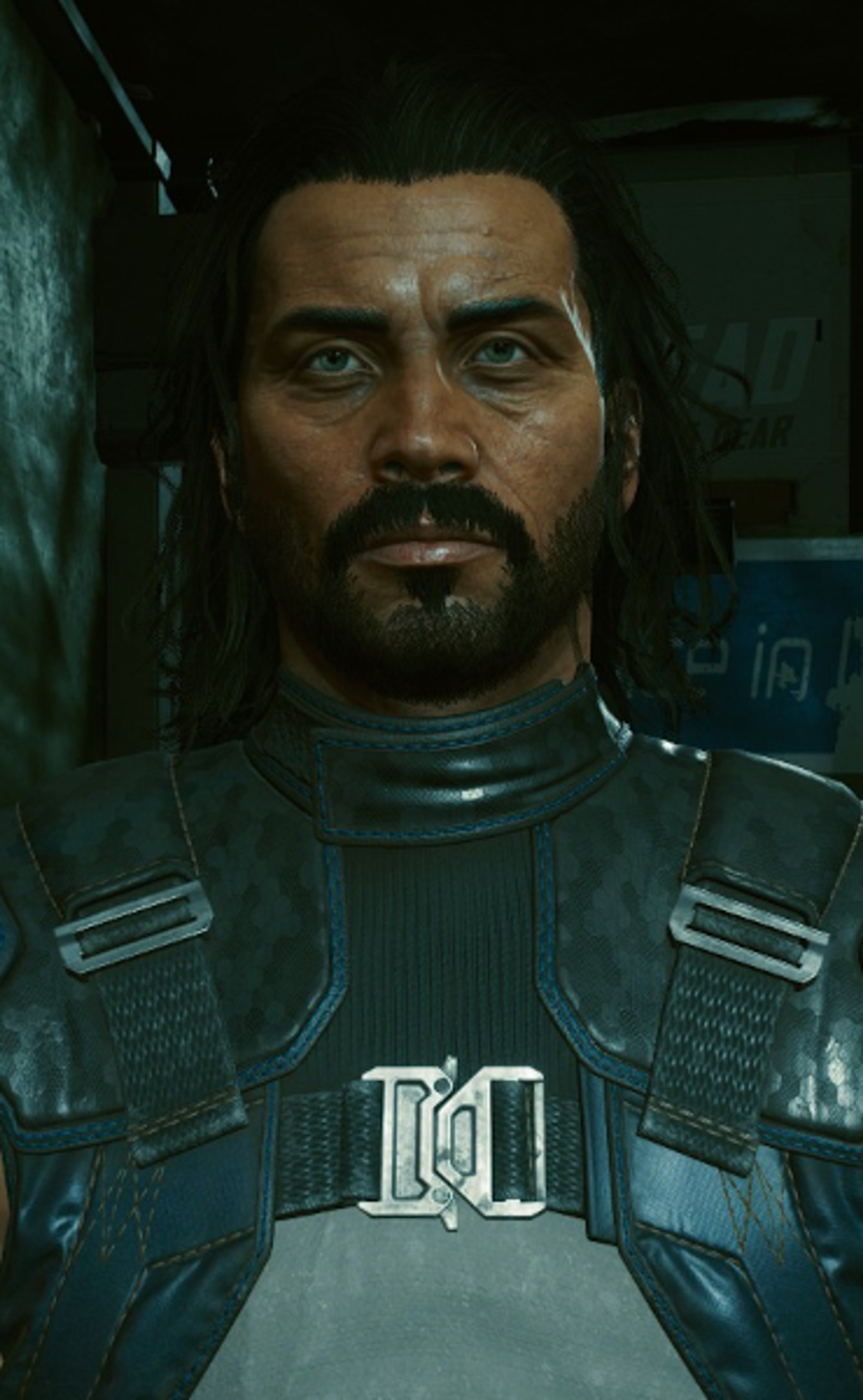 A close-up portrait of a middle-aged man with a rugged, weathered appearance wearing tactical gear.