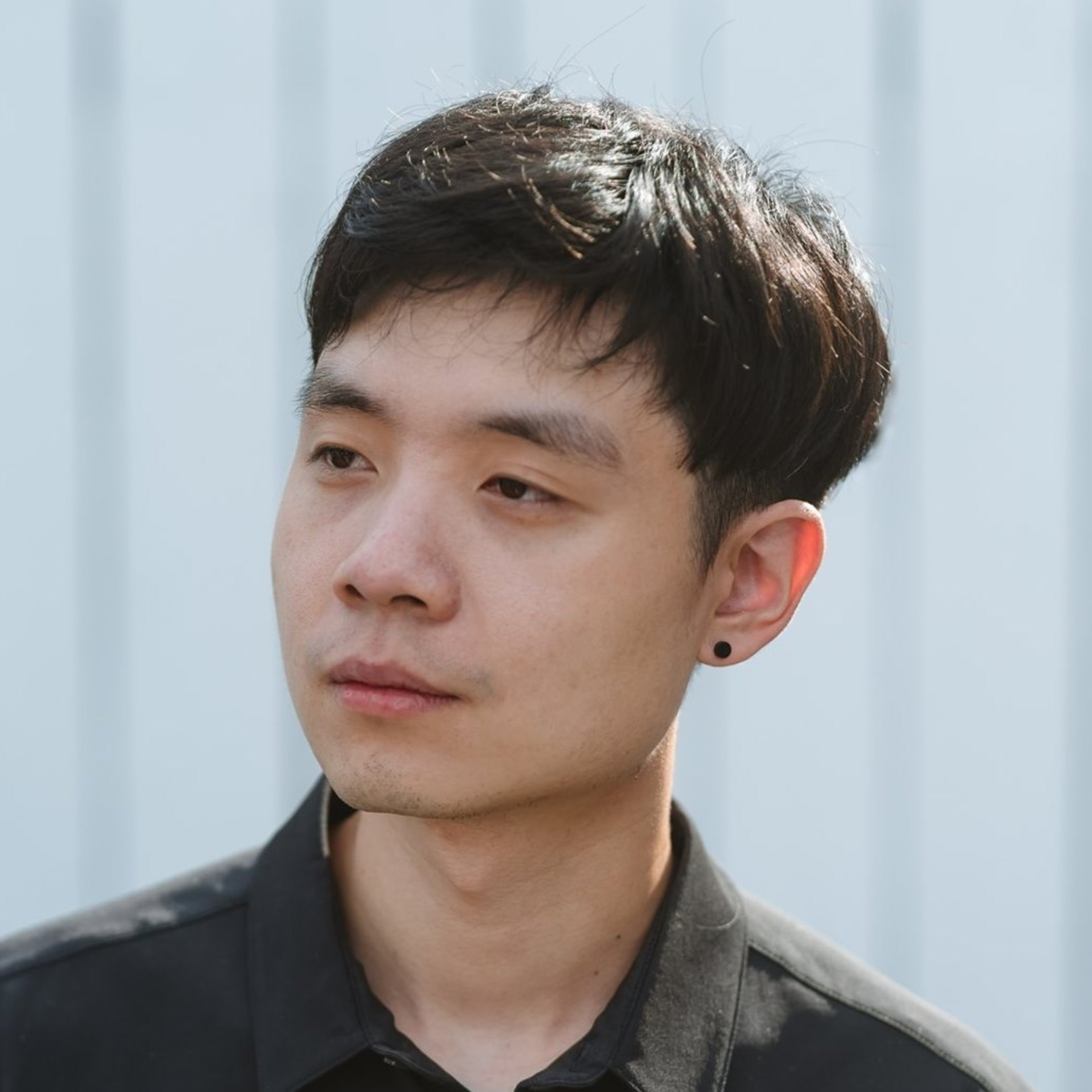 A young Asian man with short dark hair wearing a black shirt