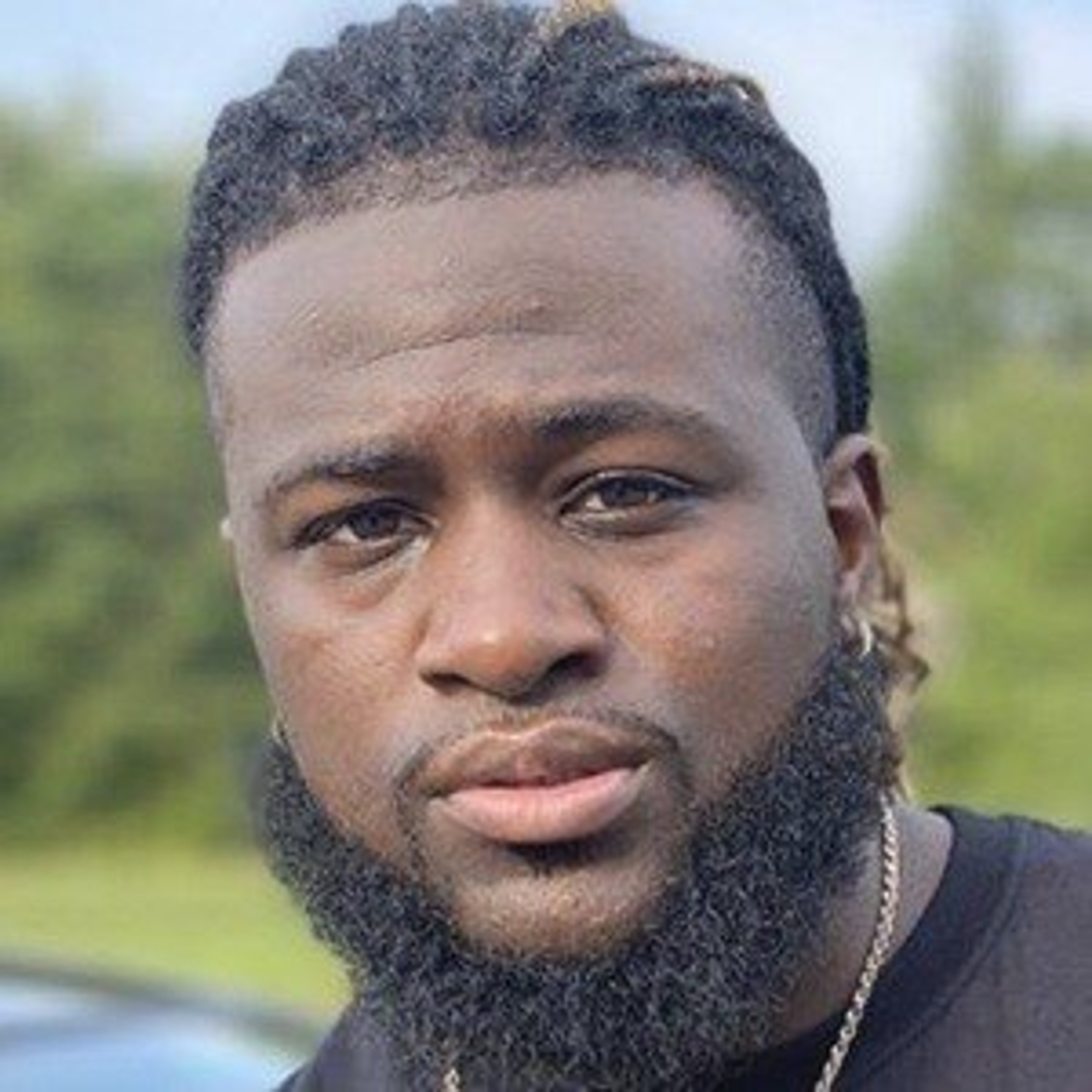 Portrait of a Black man with a beard and curly hair