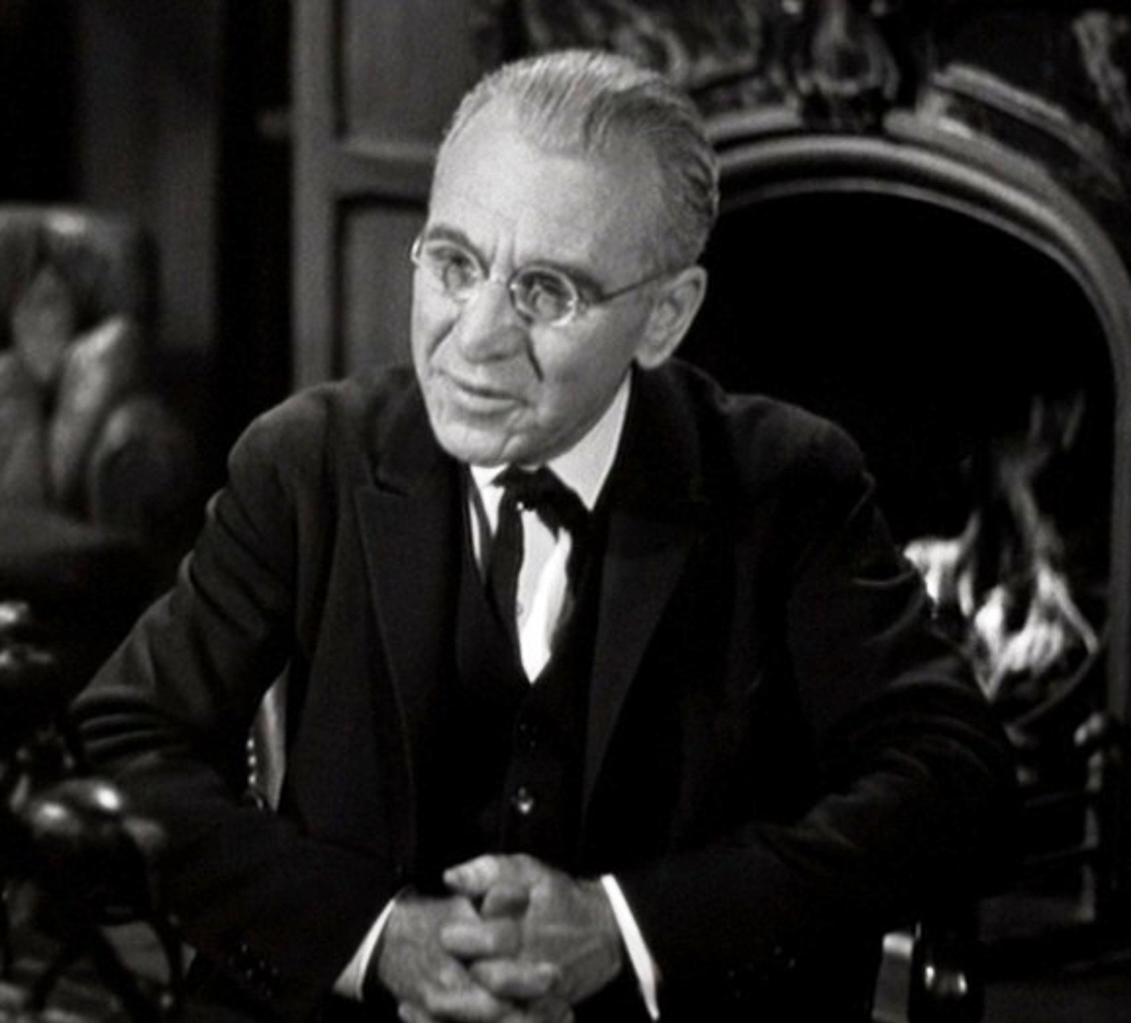 An older man in a suit and tie with a serious expression
