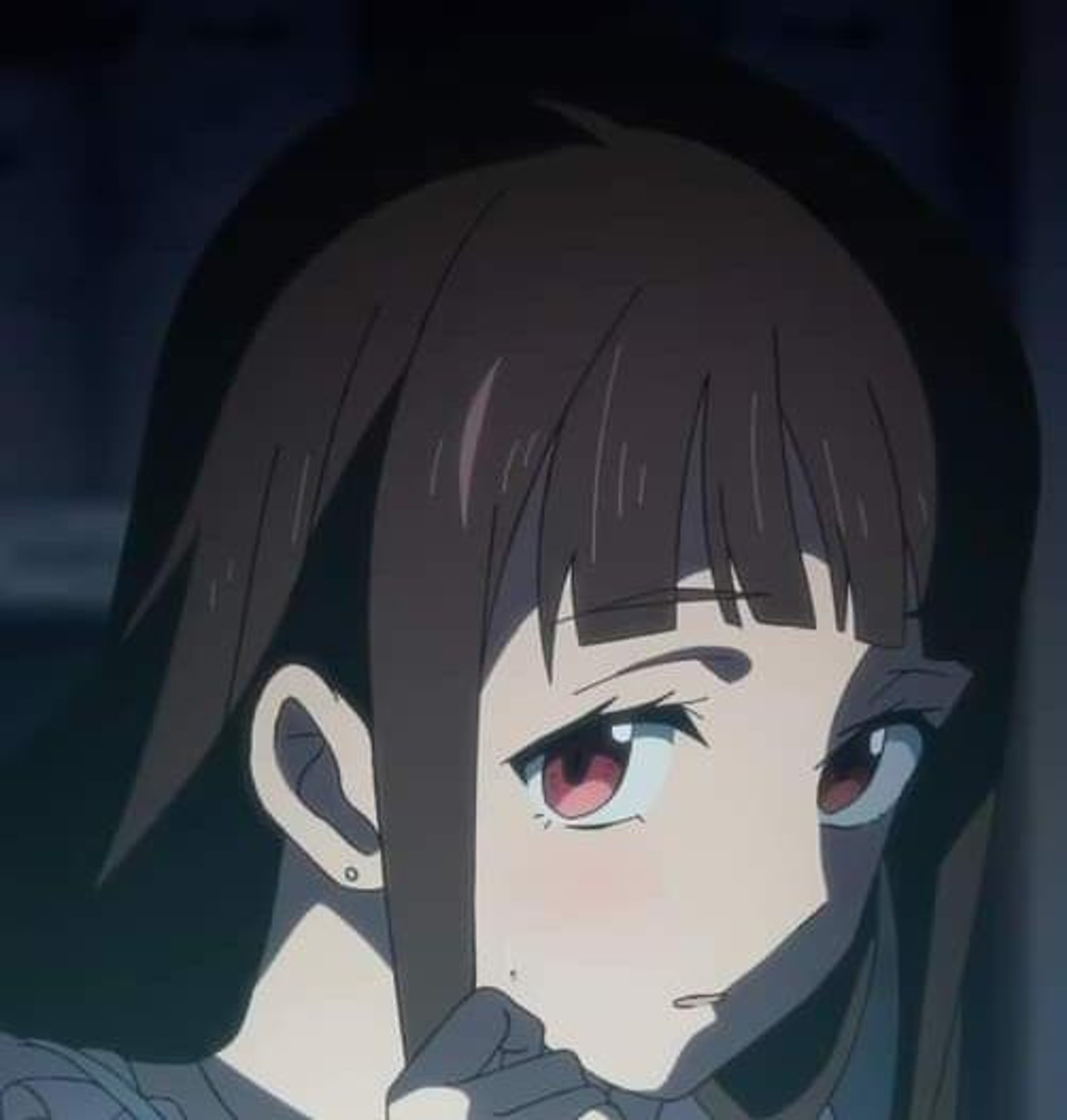 A young woman with short, dark hair and red eyes looking concerned