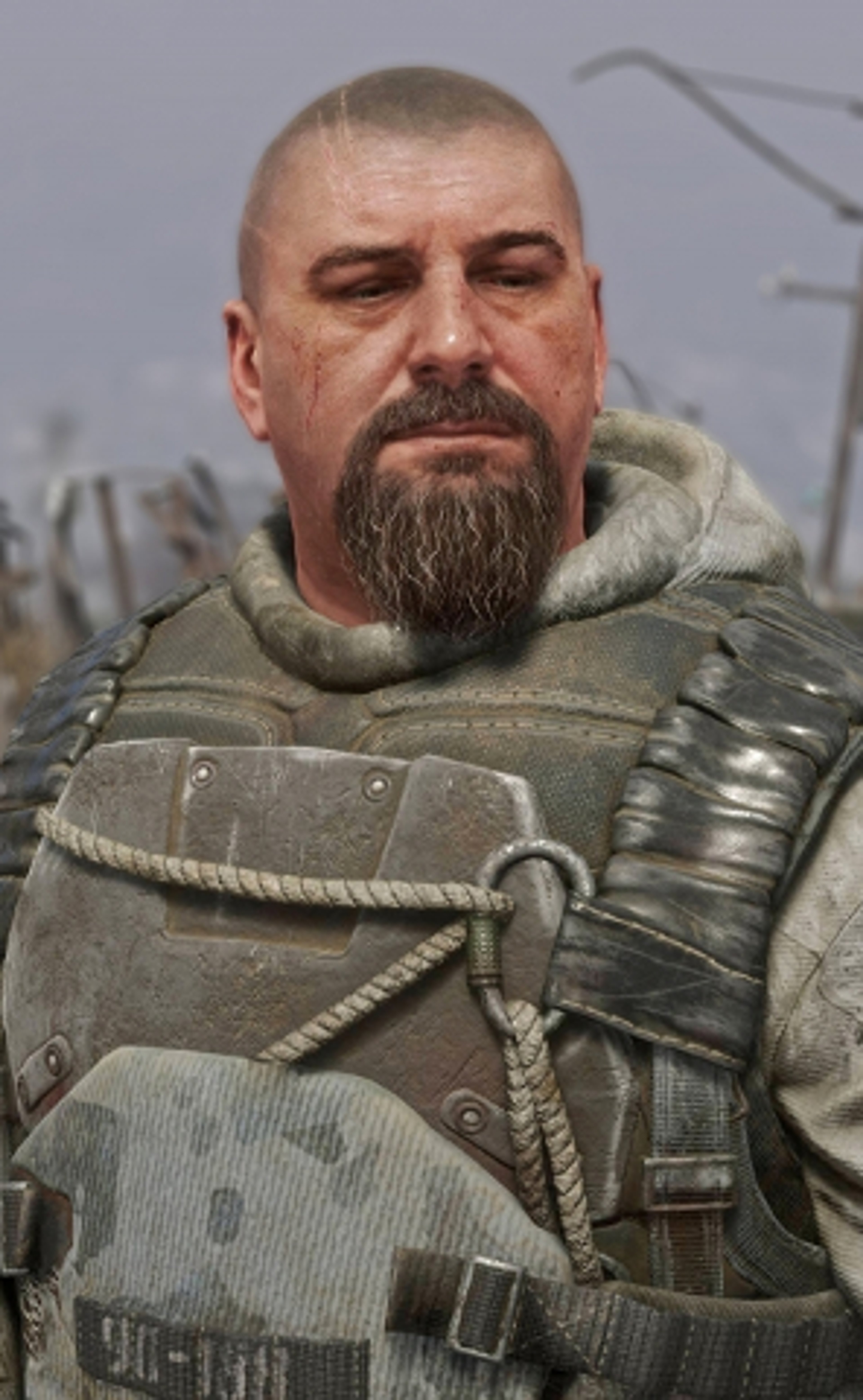 A middle-aged man with a bald head and thick beard wearing a military-style jacket