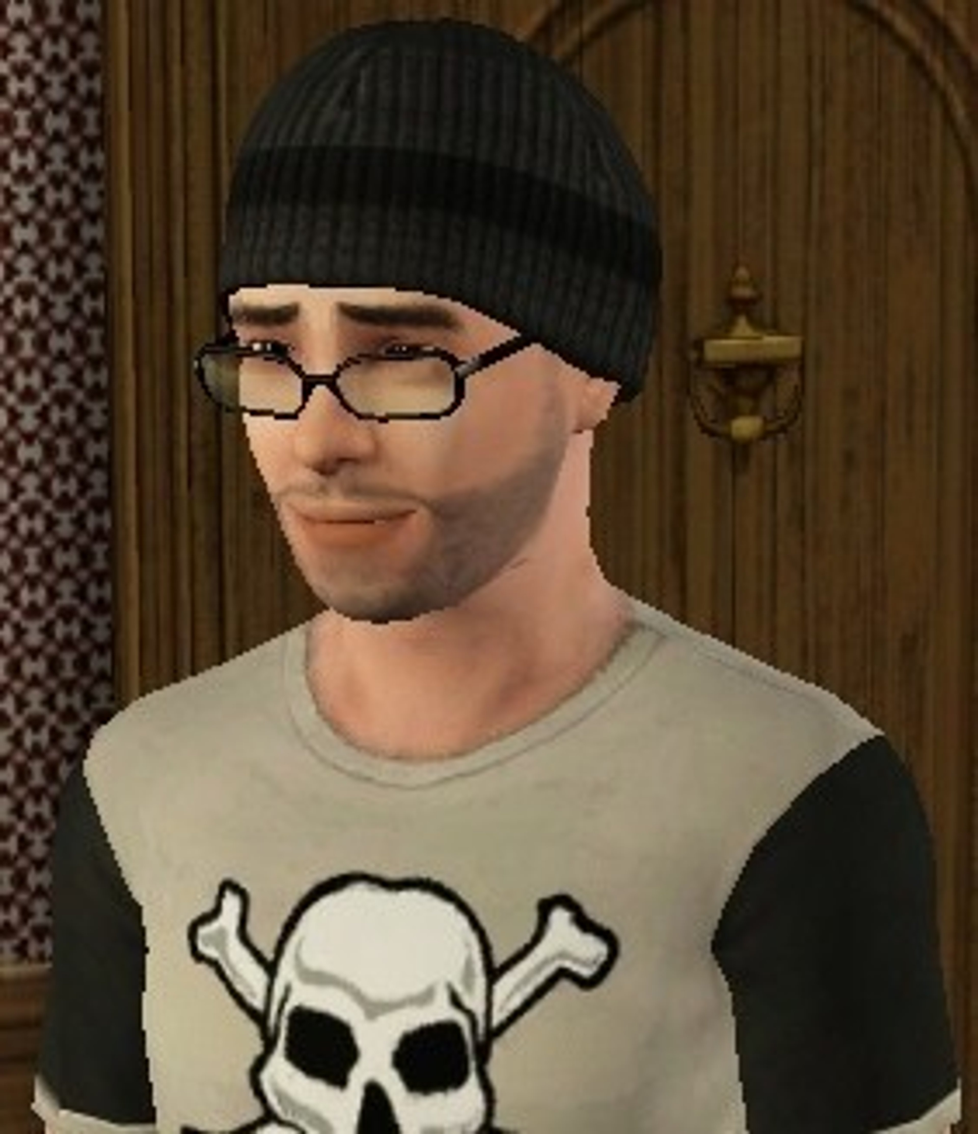 A young man with dark hair and glasses wearing a black beanie and a t-shirt with a skull graphic
