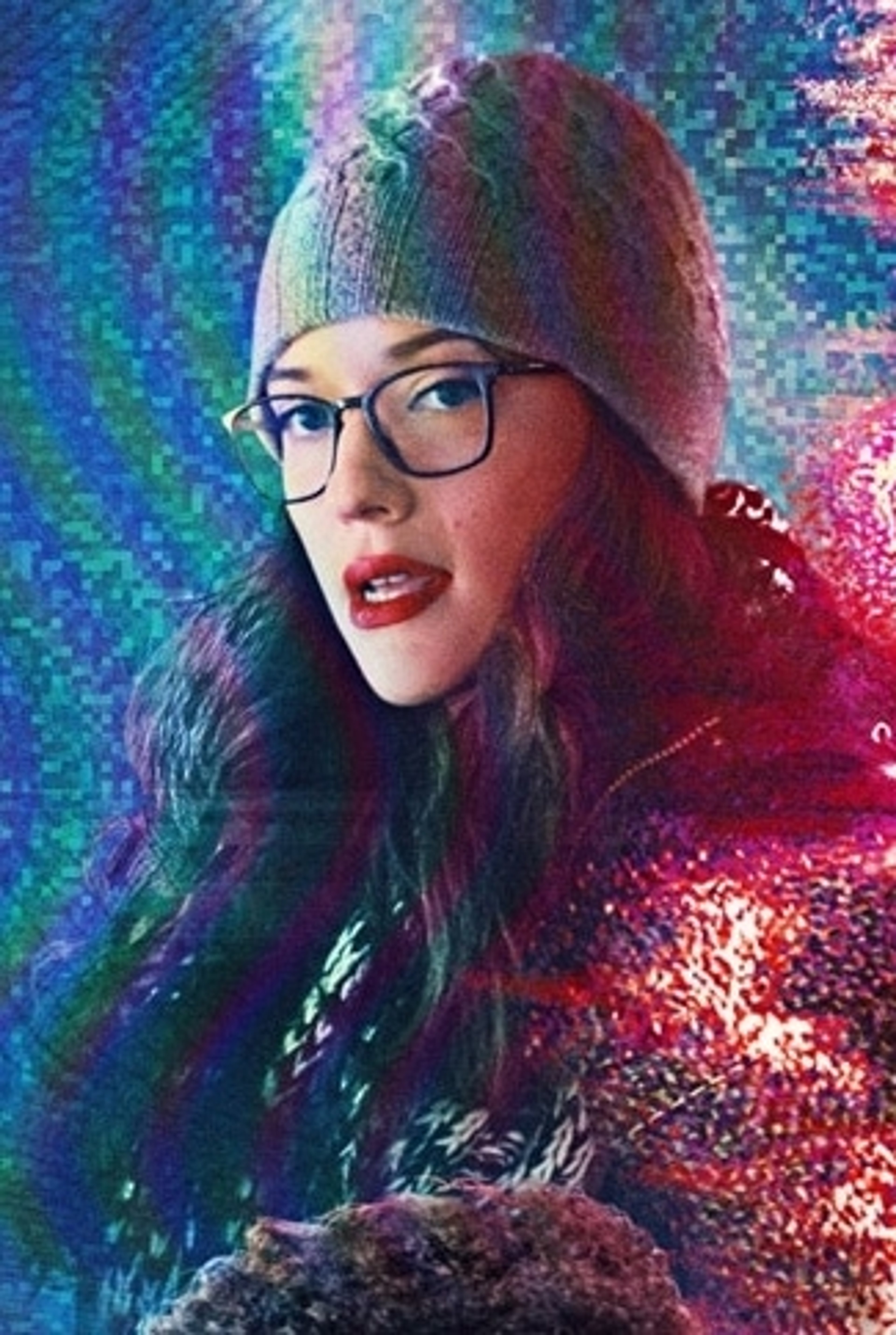 A woman with dark hair and glasses wearing a red hat against a colorful, pixelated background.