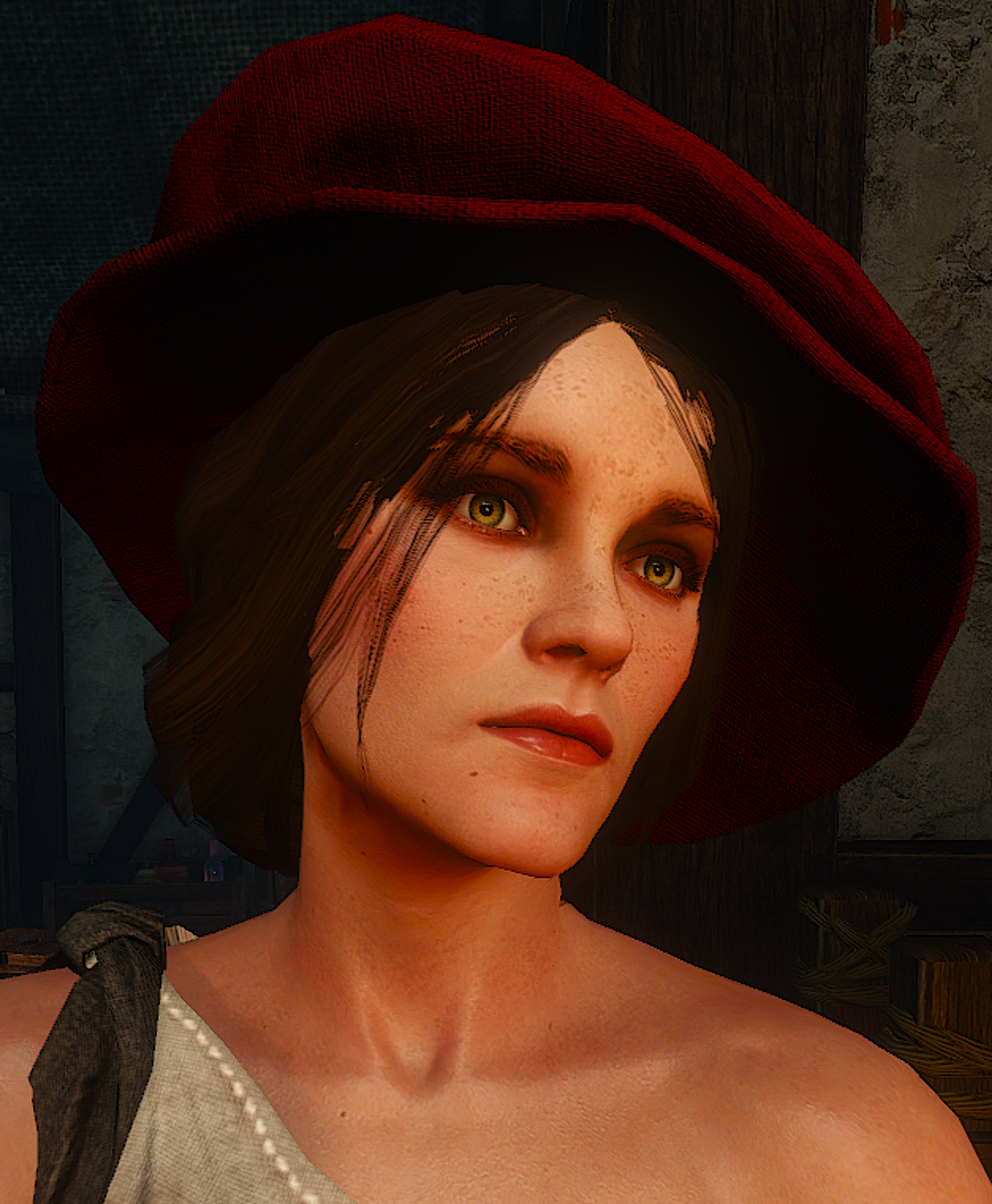 A young woman with brown hair and green eyes wearing a red hat