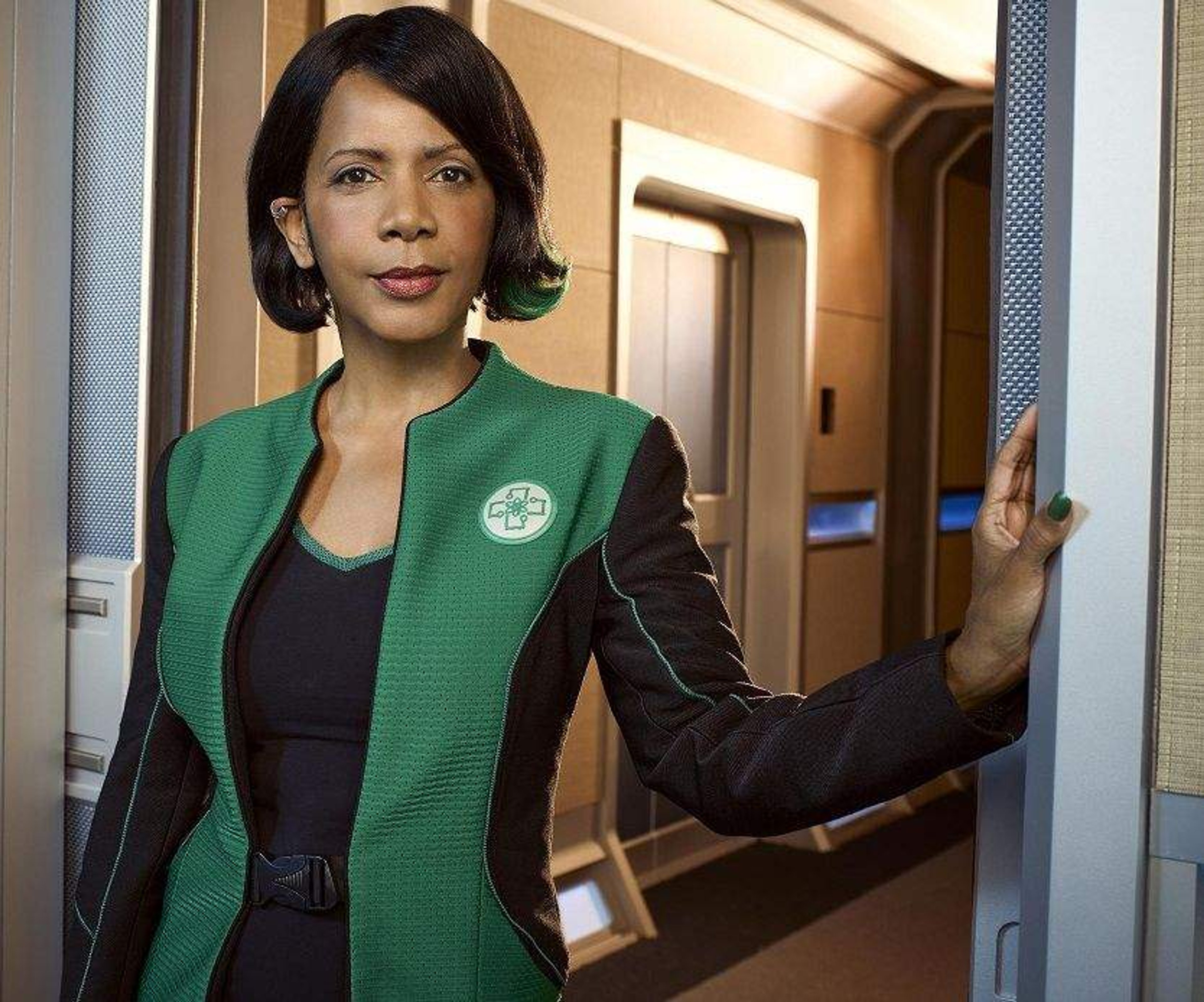 A woman in a green jacket standing in a professional setting