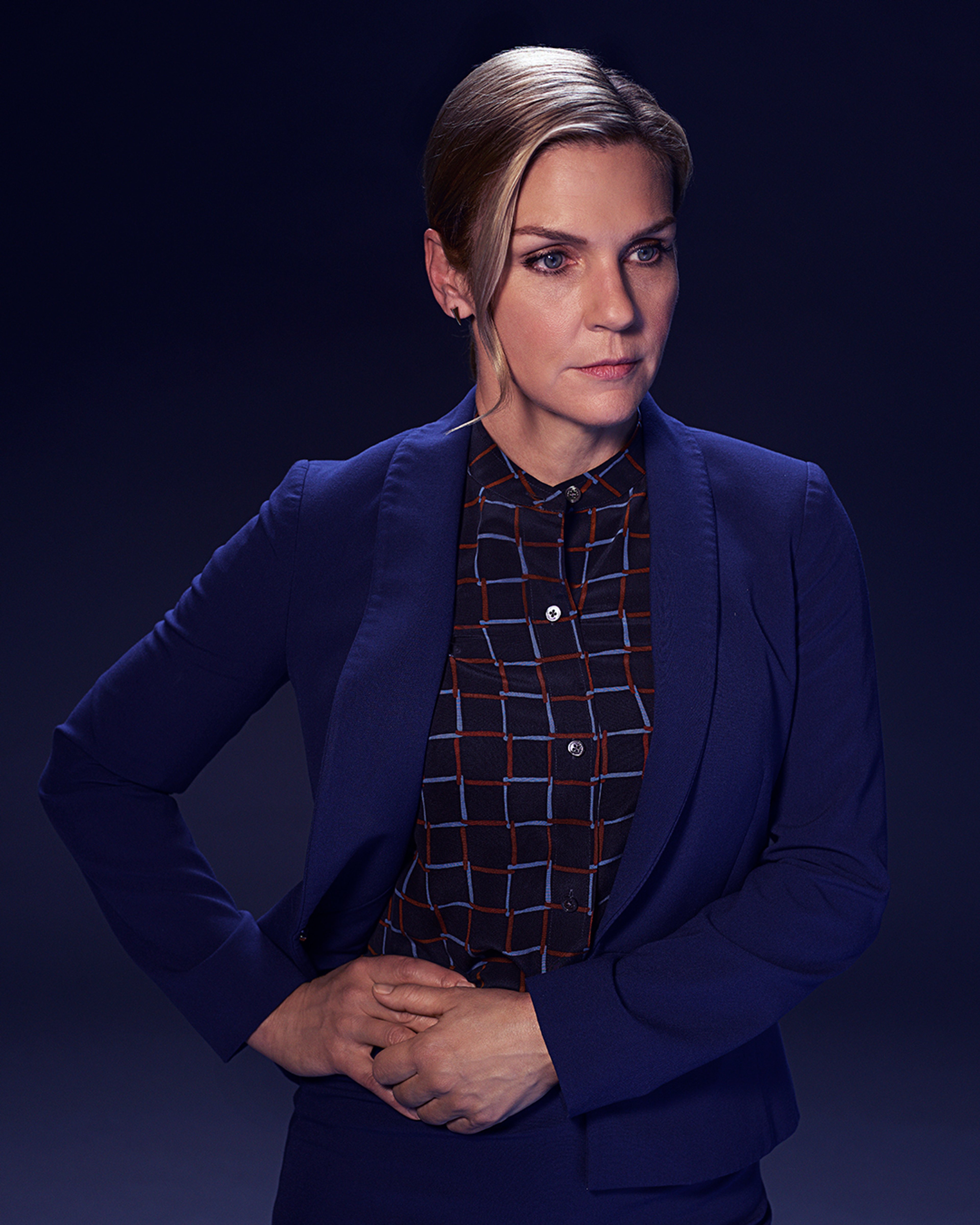 A woman in a blue blazer with a serious expression