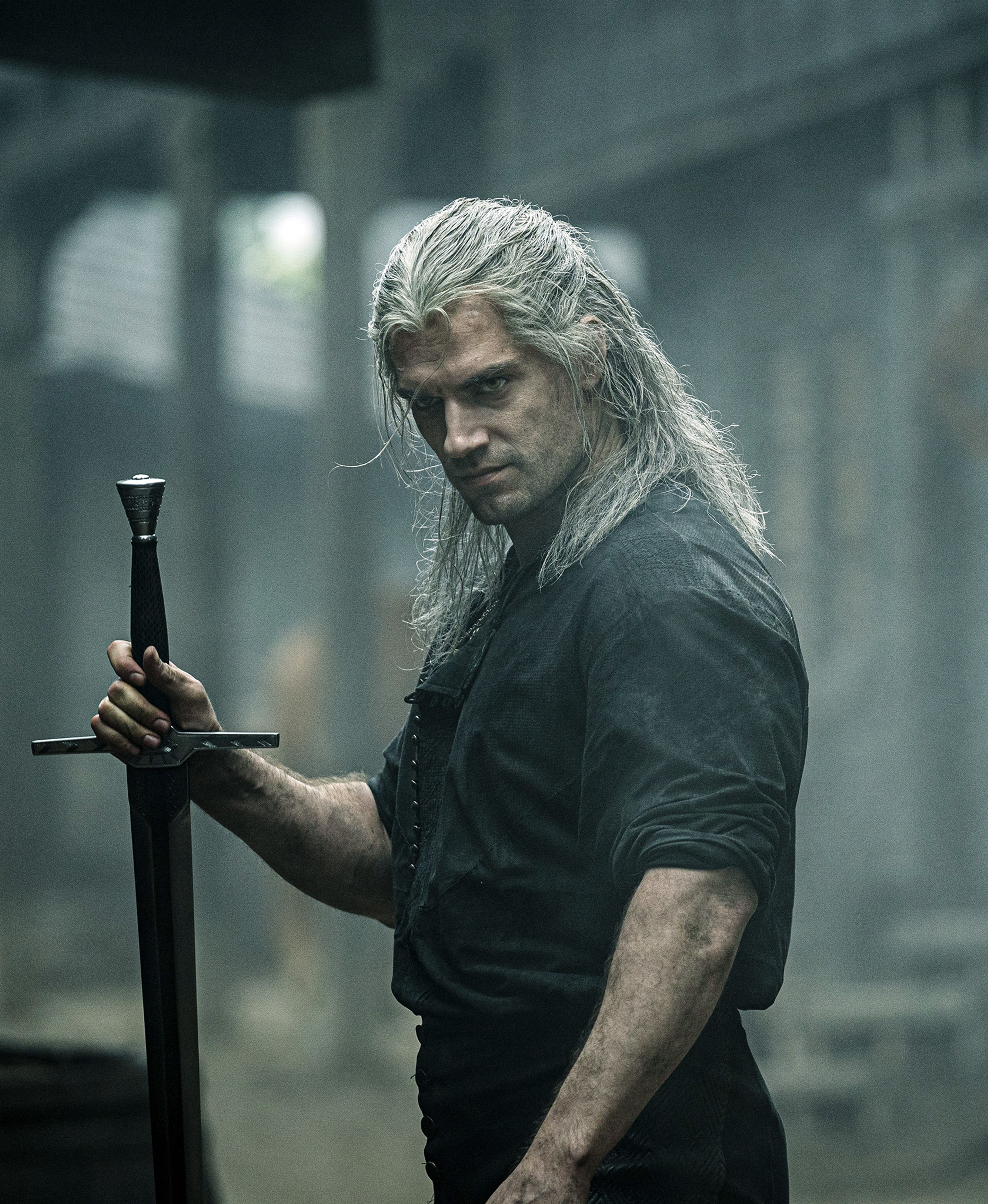 A man with long white hair holding a sword in a dark, gritty setting