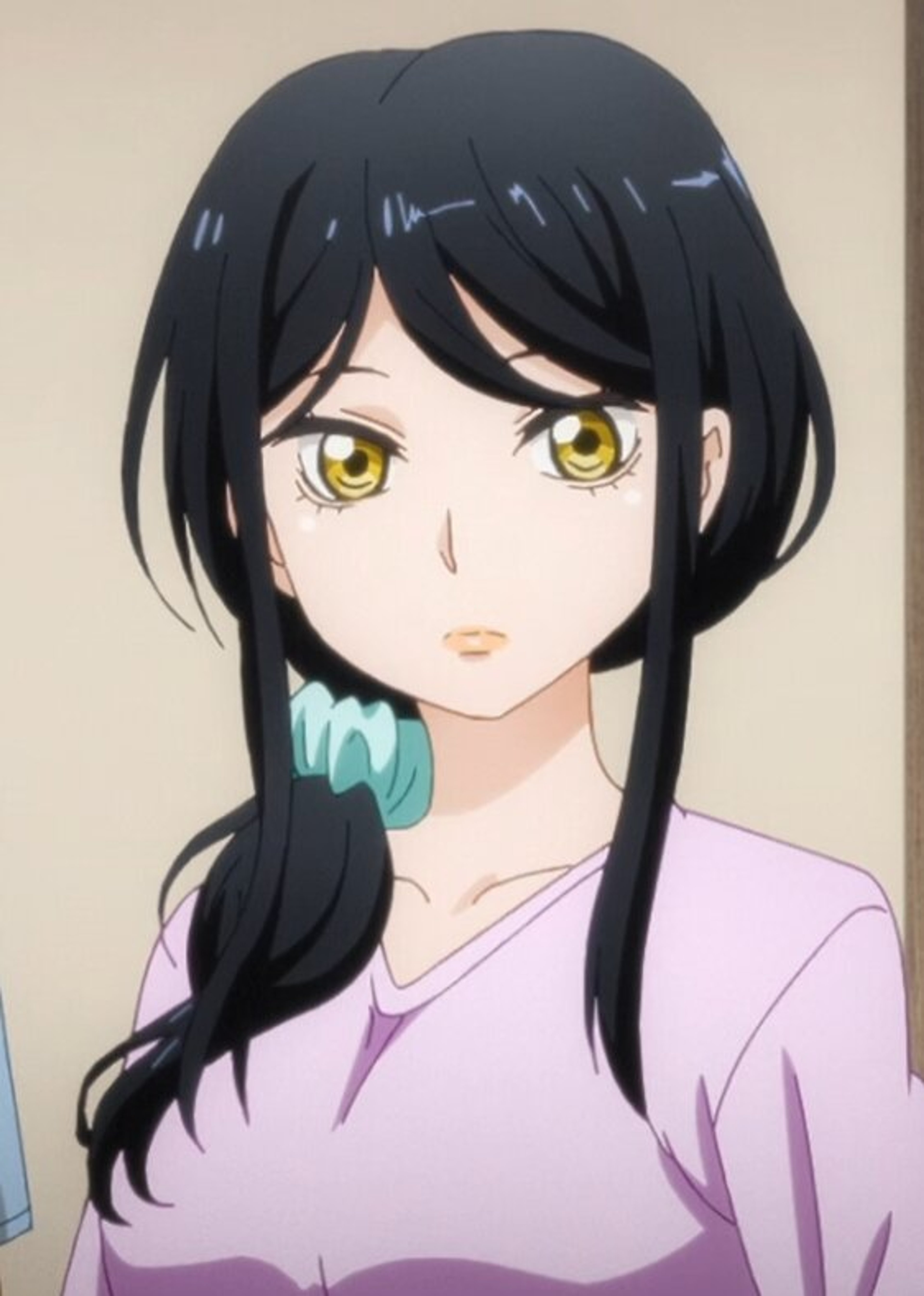 A woman with long dark hair and golden eyes, wearing a light pink shirt