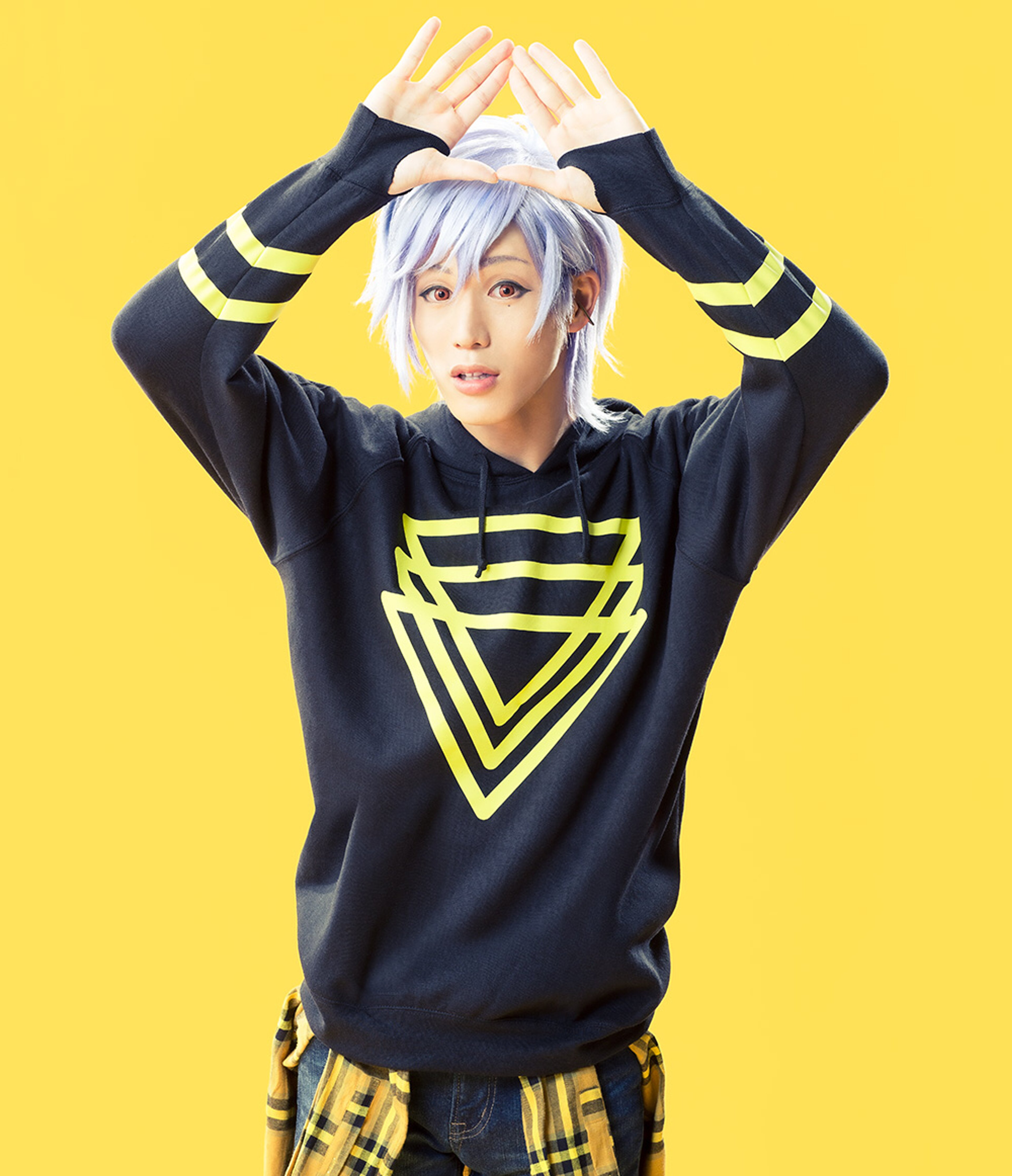 A young man with light purple hair and orange eyes wearing a dark green hoodie with triangle patterns.