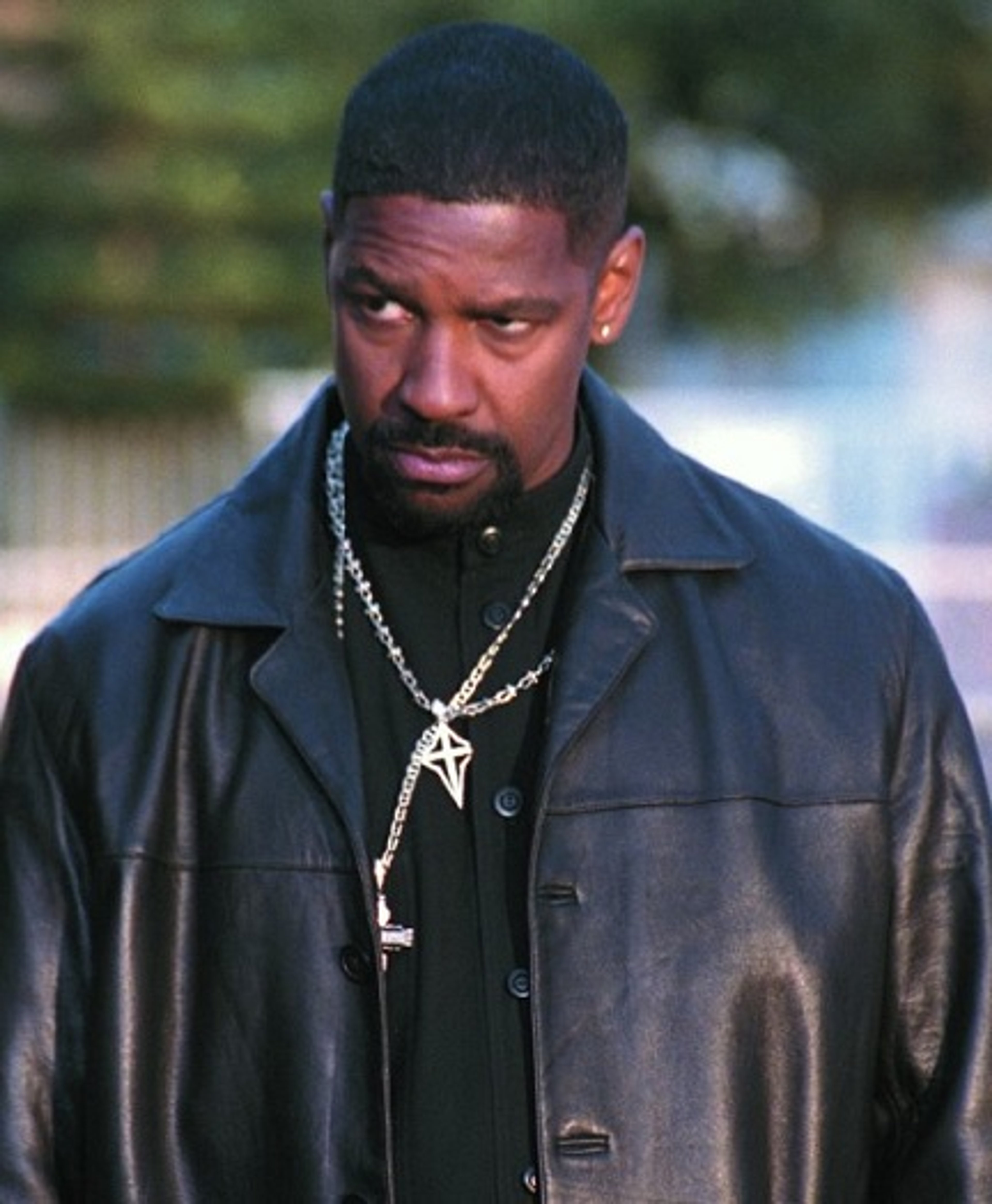 A serious-looking African American man in a black leather jacket