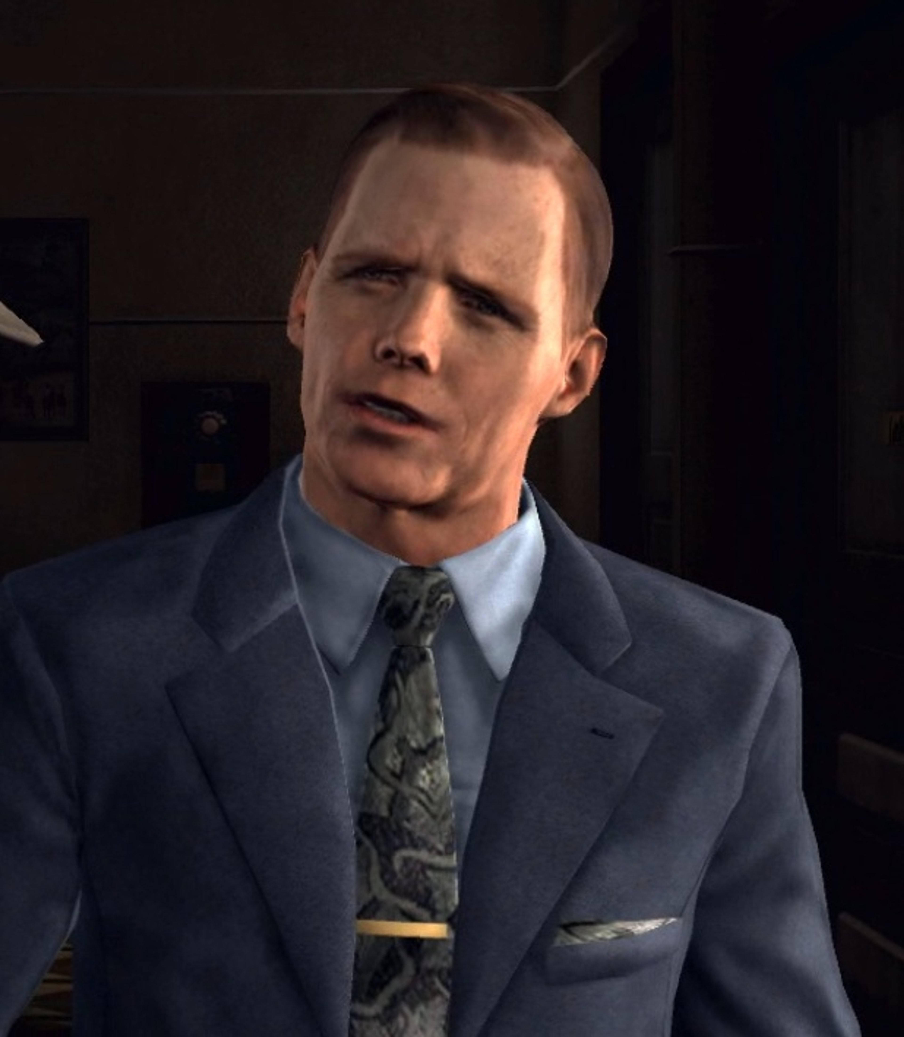A middle-aged man in a suit and tie, with a stern expression on his face.