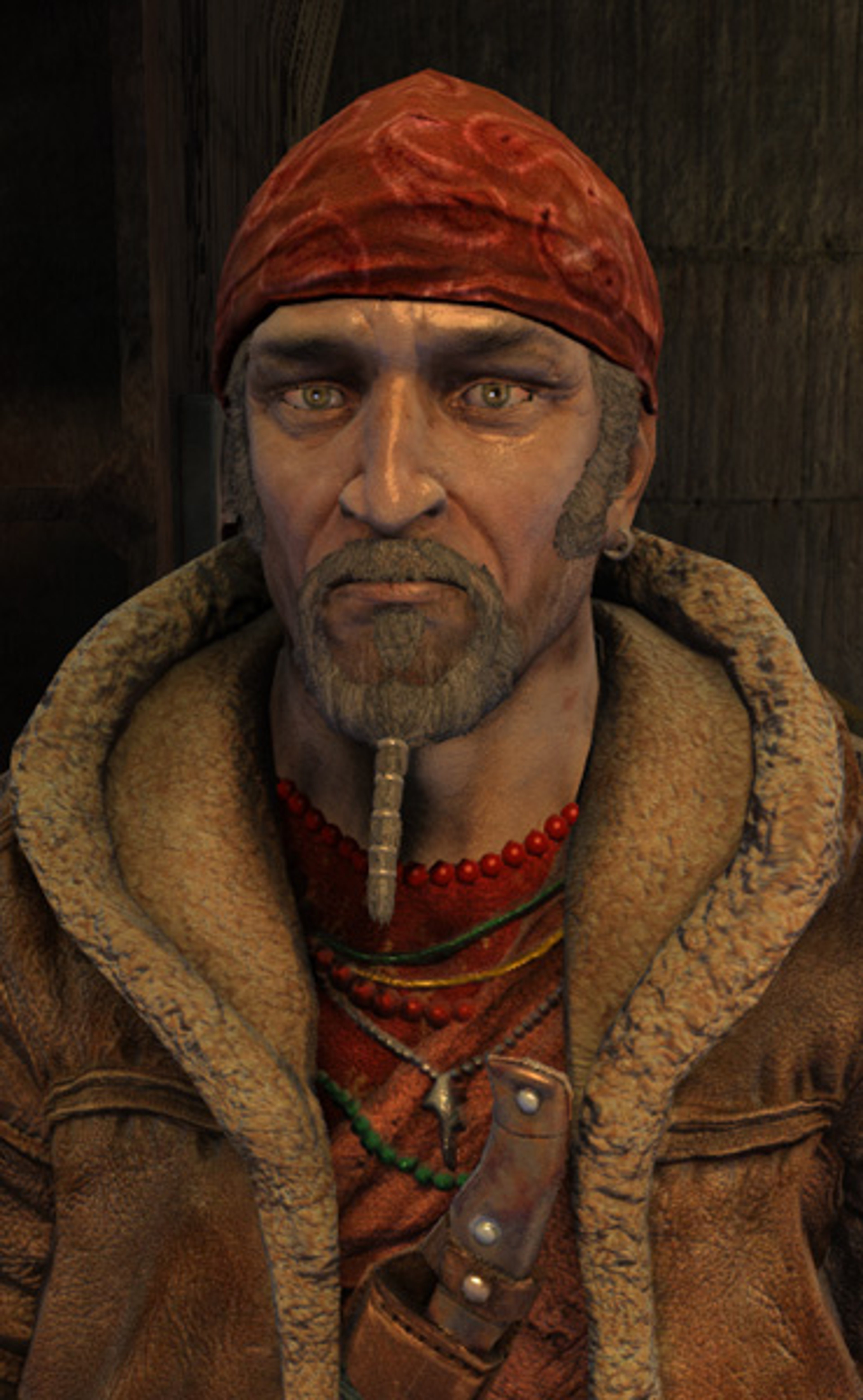 A weathered, older man with short graying hair, a beard, and piercing eyes, wearing a red hat and fur-lined coat.